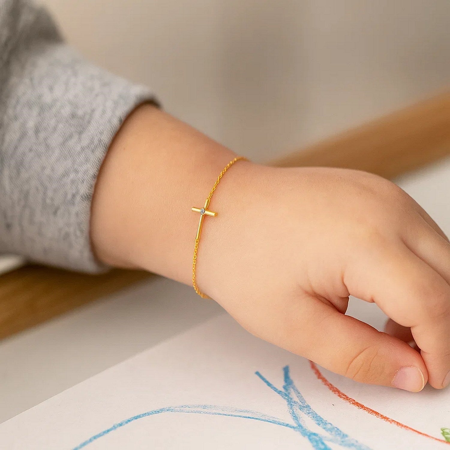 14k yellow gold children's bracelet featuring an elegant cross design on a delicate chain, perfect for young ones.