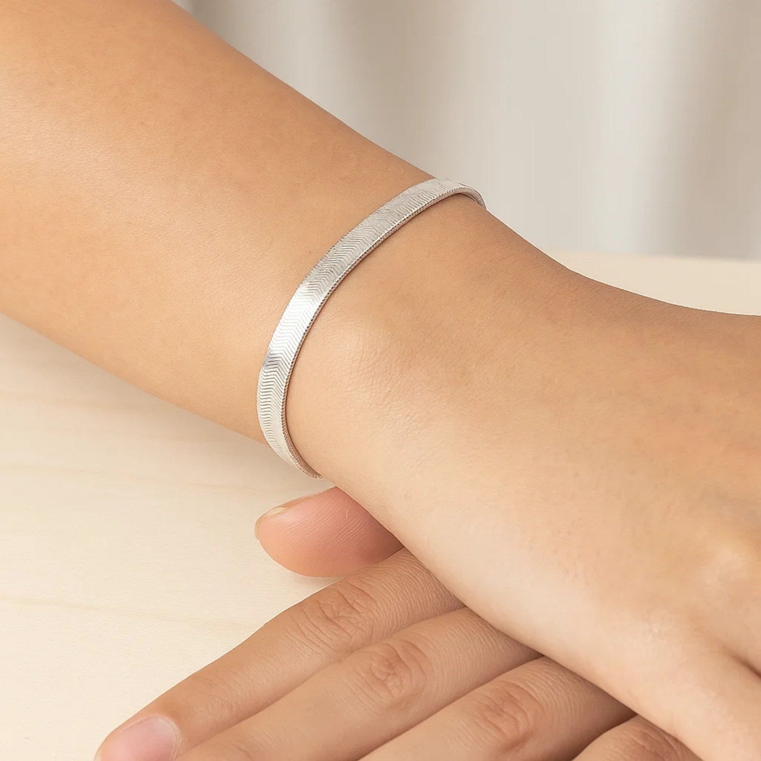 14k white gold modern herringbone bracelet featuring a flexible design and sleek stud chain detail.