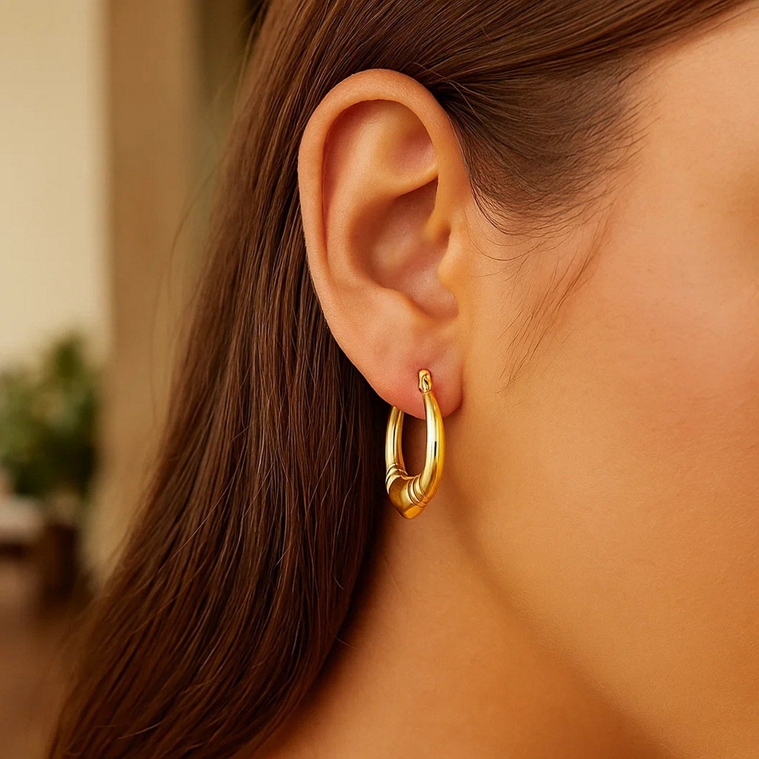 14K yellow gold polished heart hoop earrings showcasing a modern design and luxurious shine from every angle.