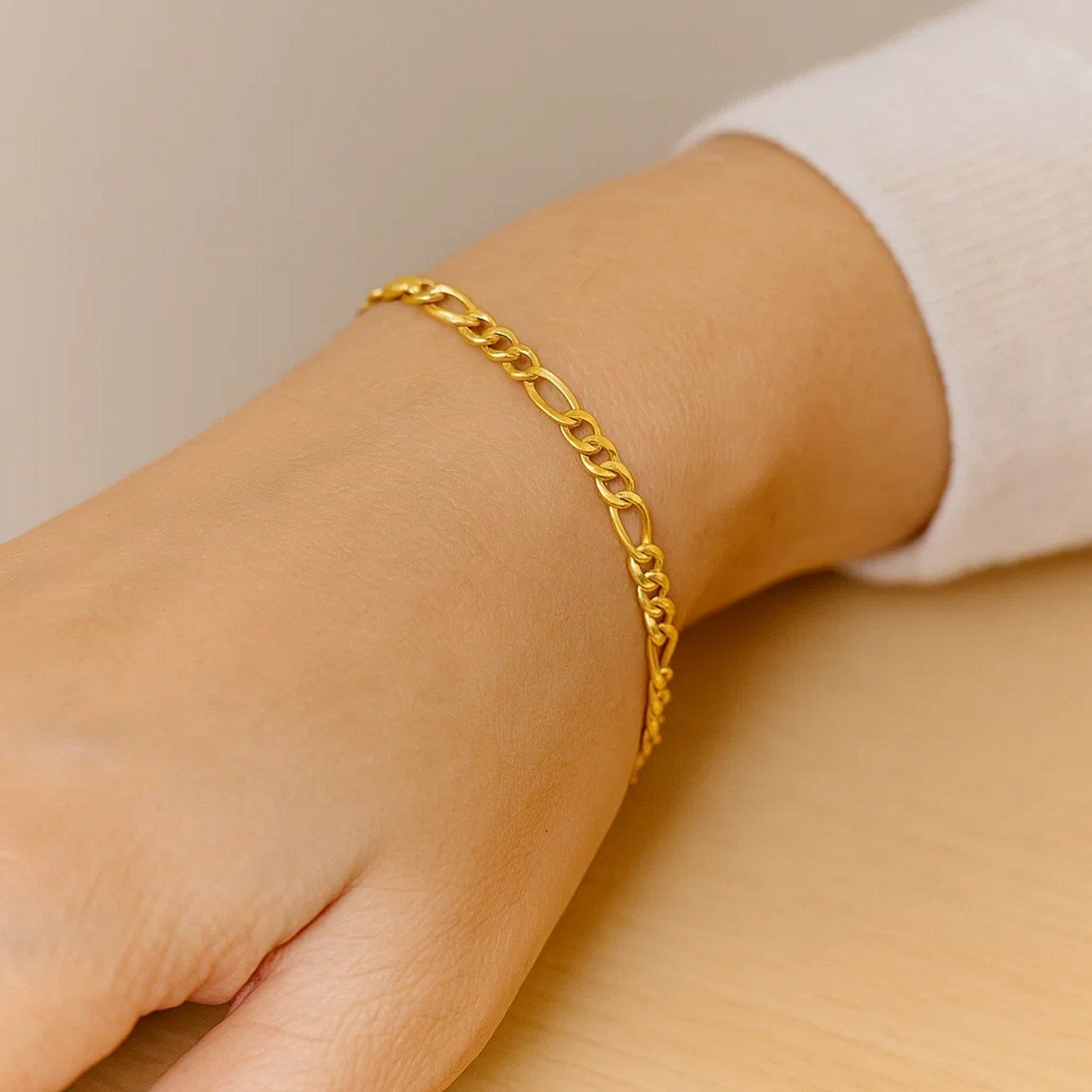 14k yellow gold solid Figaro bracelet with modern link design, showcasing elegance and timeless luxury.