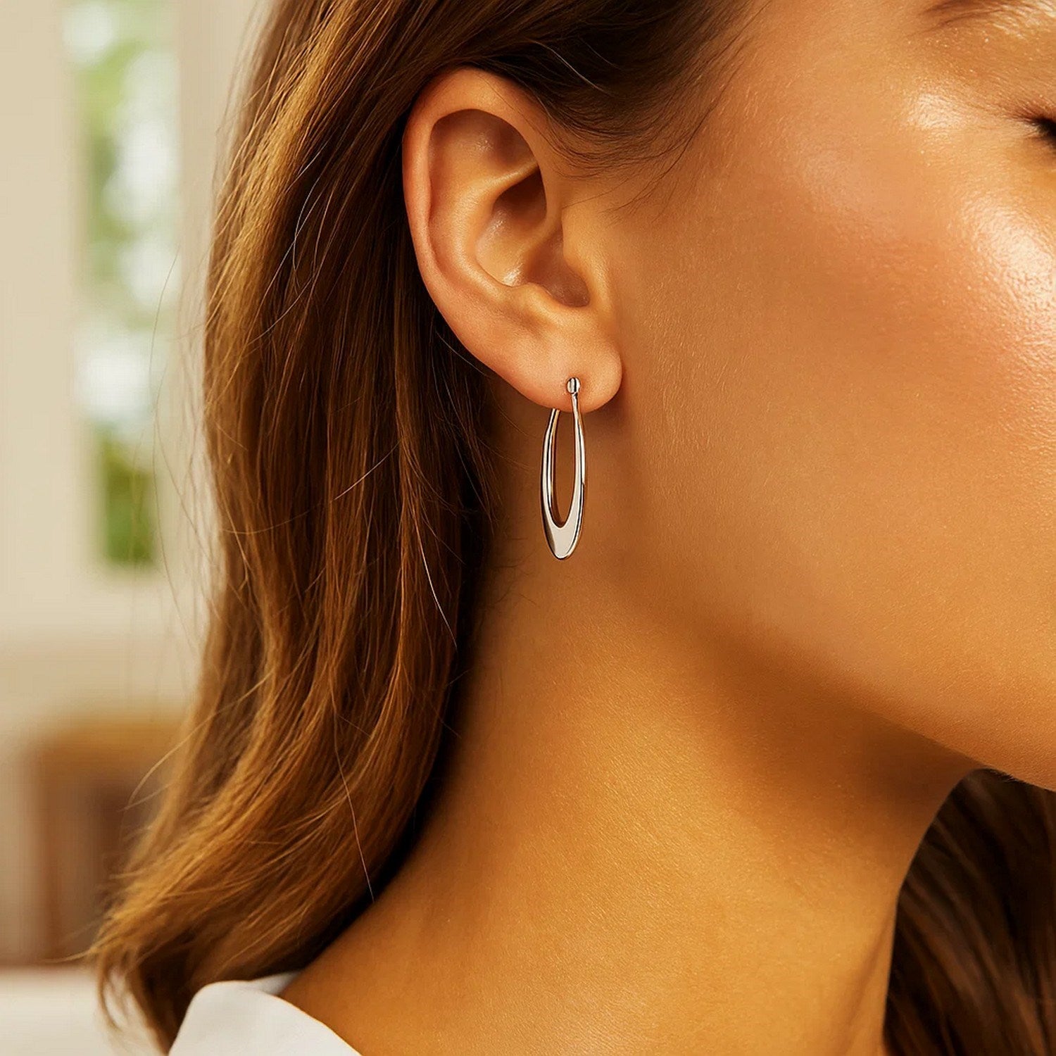 Polished 14k white gold graduated oval hoop earrings, showcasing modern elegance and refined craftsmanship.