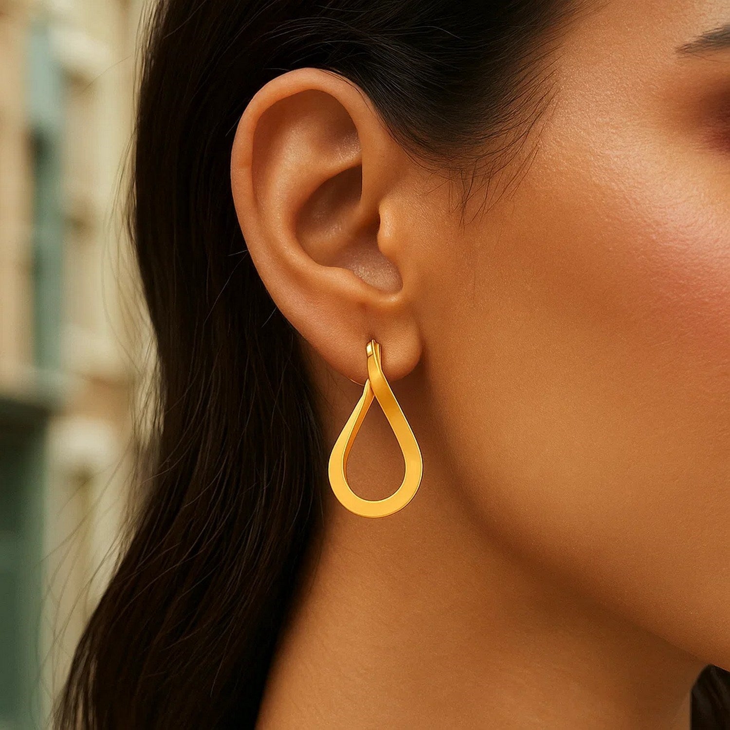 14k yellow gold polished twisted hoop earrings showcasing a modern design with a luxurious finish.