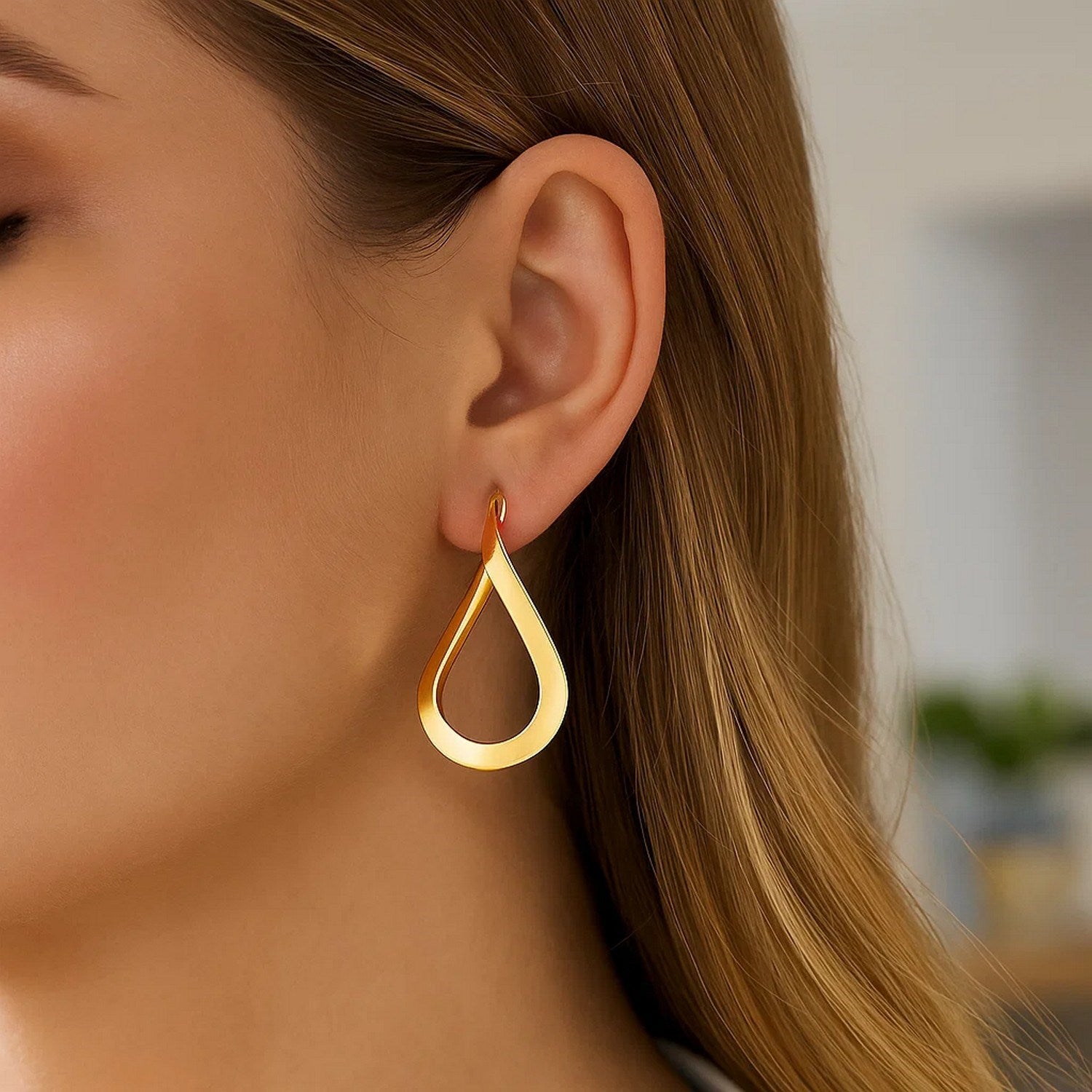 14k yellow gold polished twisted hoop earrings, showcasing a modern design with elegant curves and a luxurious finish.