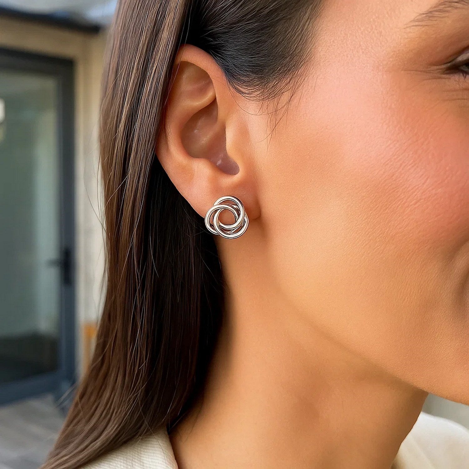 Polished sterling silver open love knot earrings with a modern design, exuding luxury and elegance.