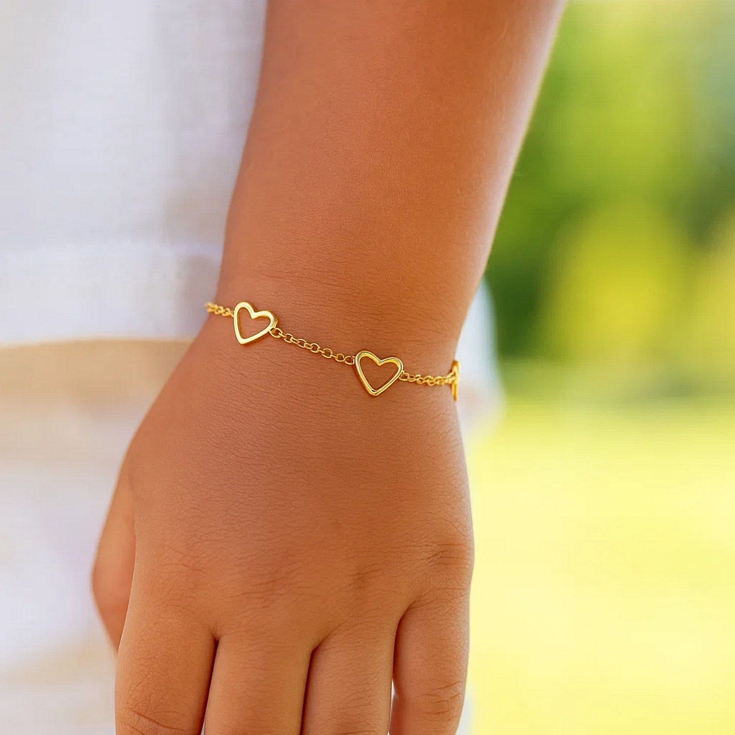 14k yellow gold children's bracelet featuring minimalist heart charms for a luxurious, timeless look.
