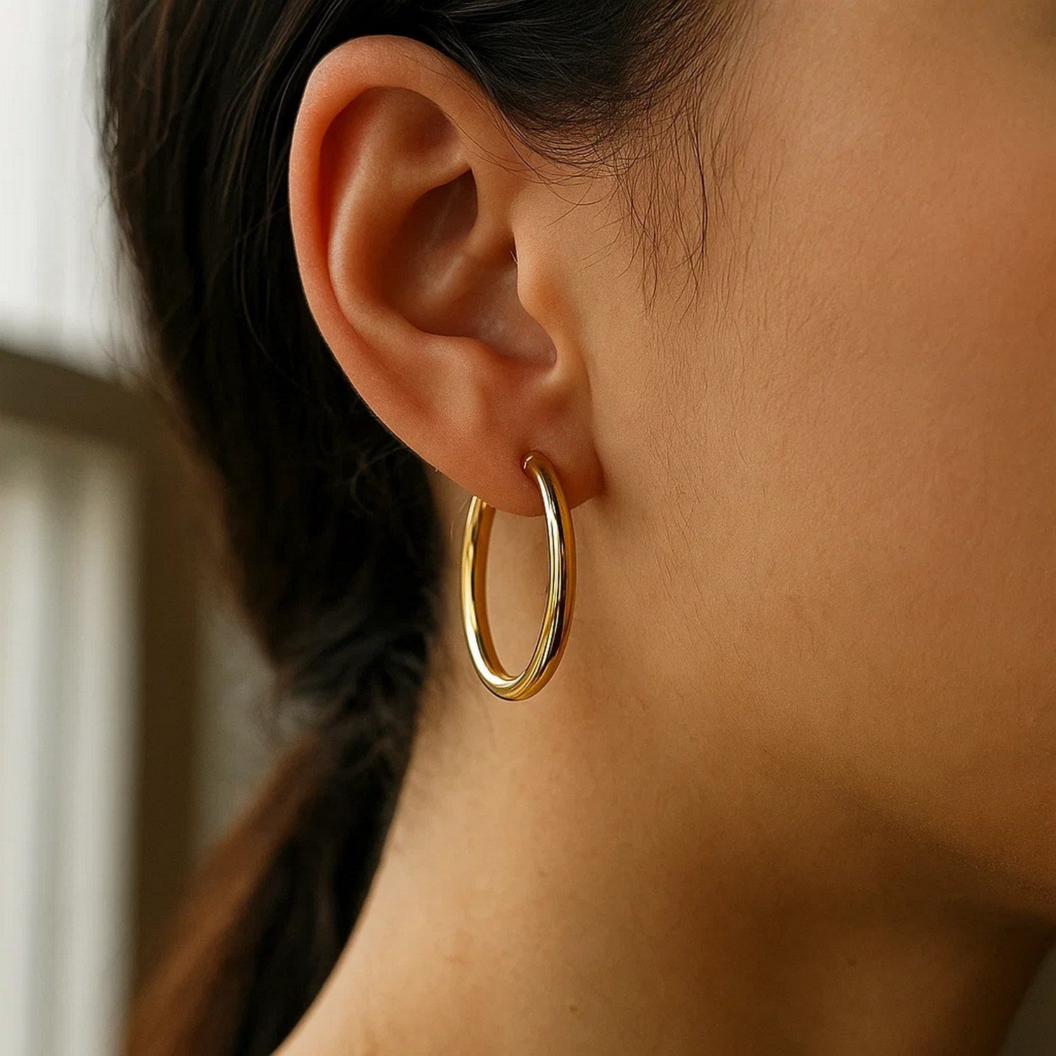 14k yellow gold polished hoop earrings, modern design, 30mm diameter, perfect for elegant everyday wear.