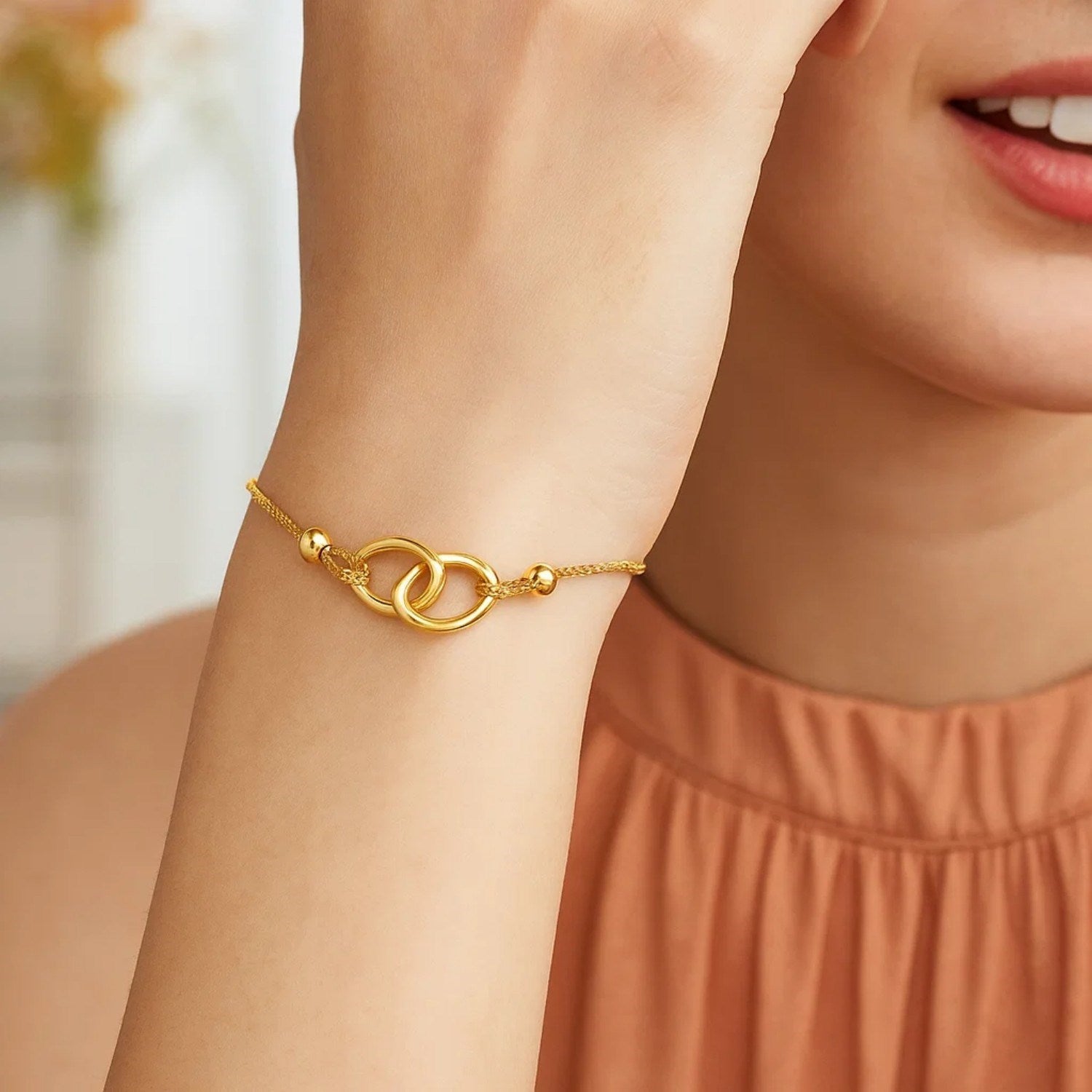 14k yellow gold adjustable lariat bracelet with entwined rings and modern chain design for a luxurious touch.