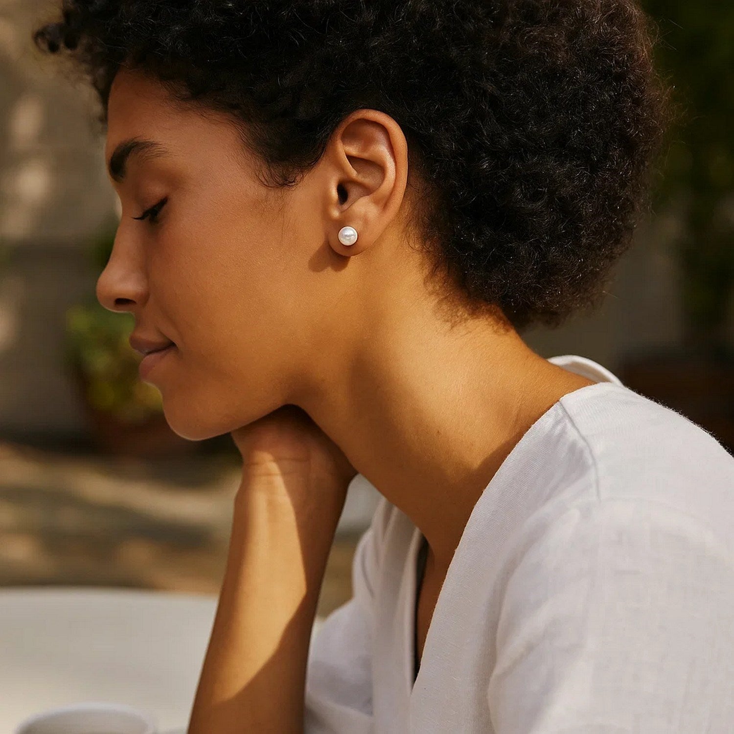 14k yellow gold stud earrings featuring lustrous freshwater cultured white pearls in a modern round design.