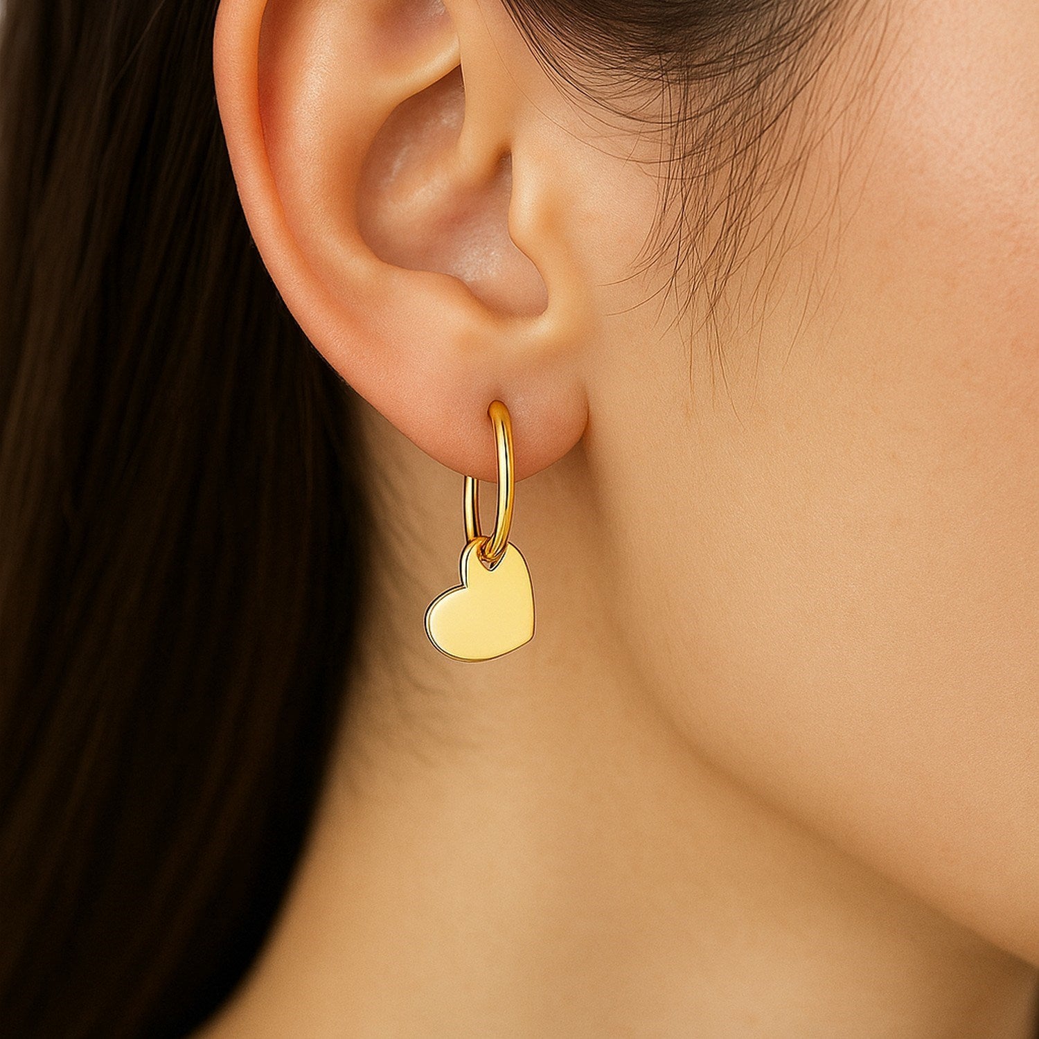 14k yellow gold polished hoop earrings featuring heart accents, exuding elegance and charm for any occasion.
