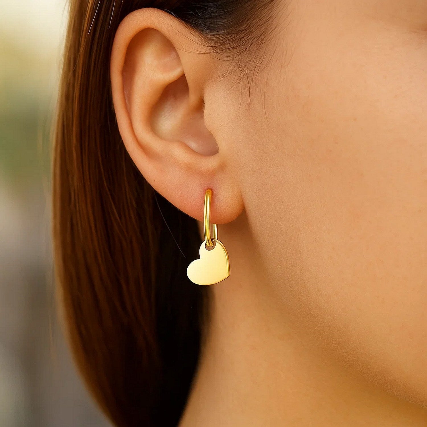 Elegant 14k yellow gold polished hoop earrings adorned with heart motifs, showcasing luxury craftsmanship.
