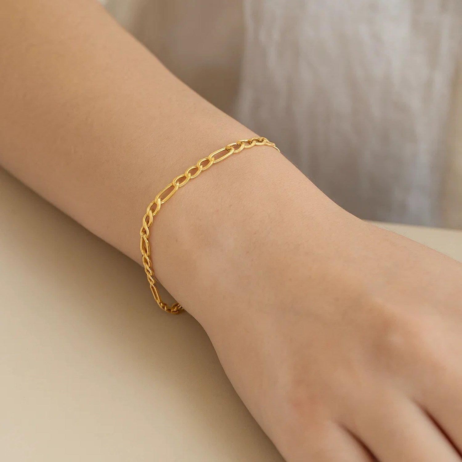 10k yellow gold Lite Figaro bracelet featuring sleek links and a modern design, perfect for luxury jewelry lovers.