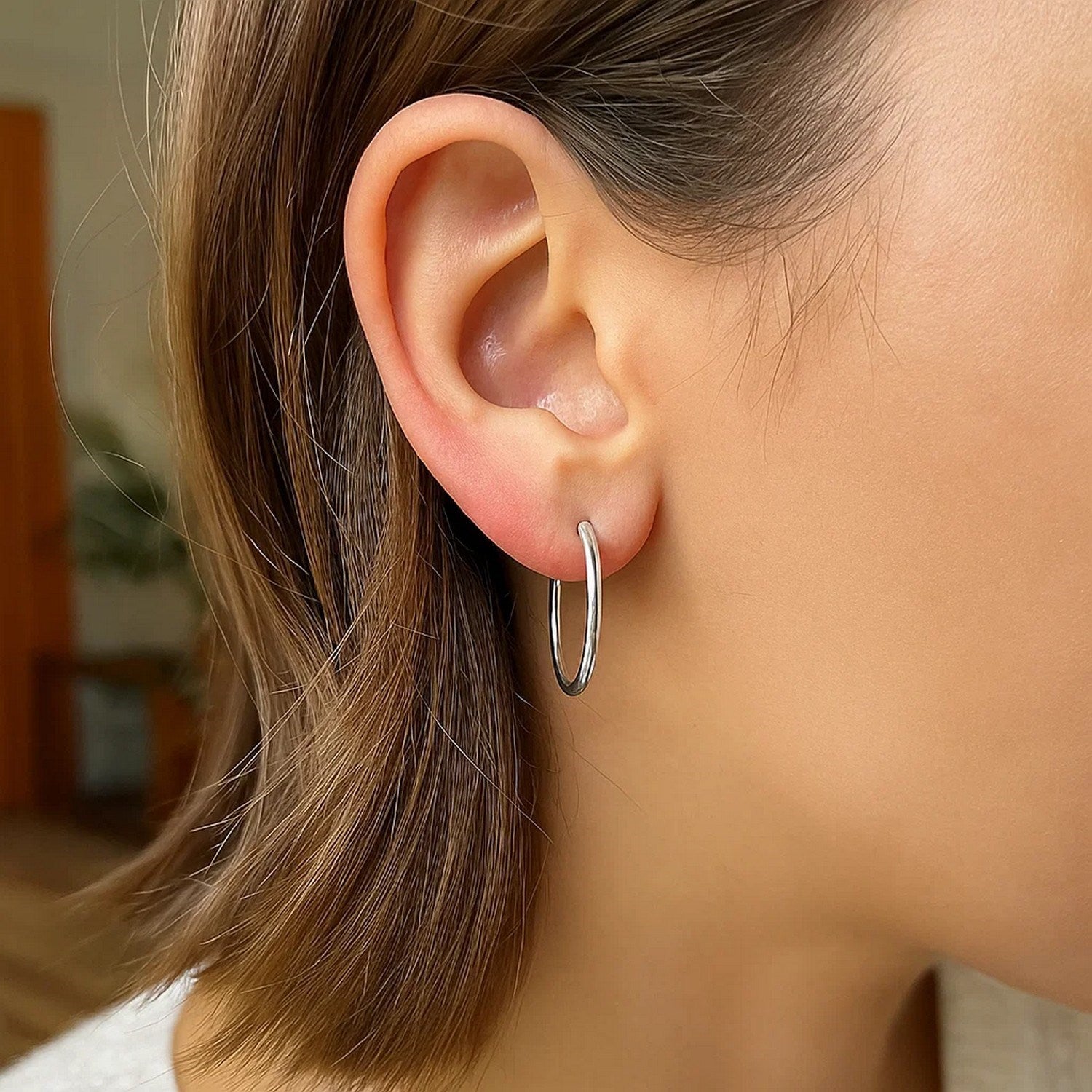 Sterling silver polished hoop earrings with a modern design, showcasing elegance and timeless style.