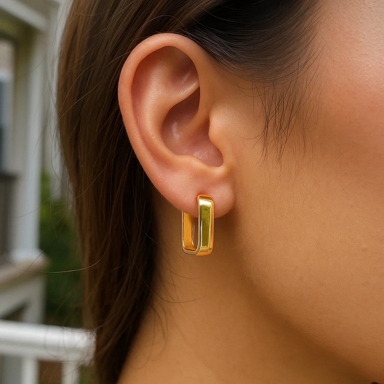 14k yellow gold polished hoop earrings showcasing a modern design with a sleek, elegant finish.
