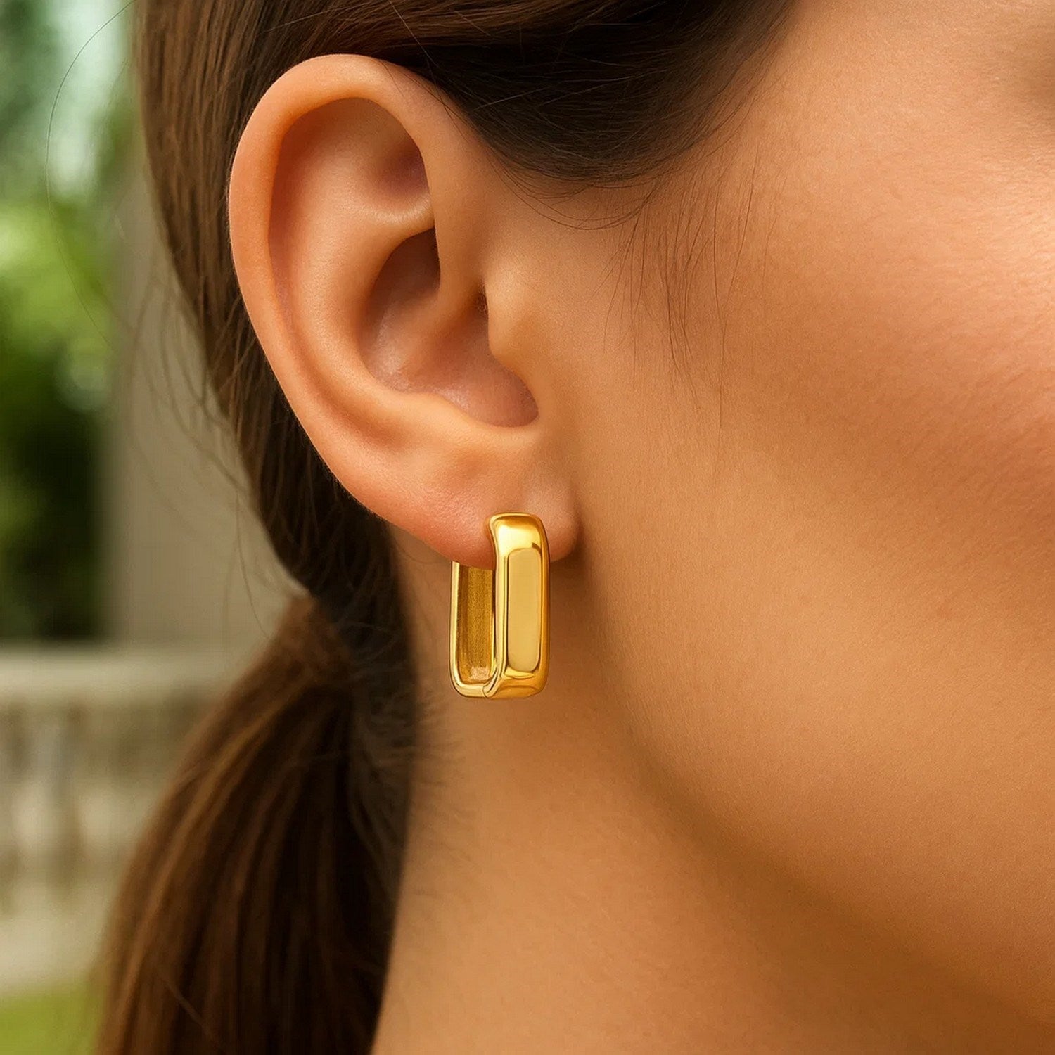 14k yellow gold polished hoop earrings showcasing a modern design with a sleek, lustrous finish.