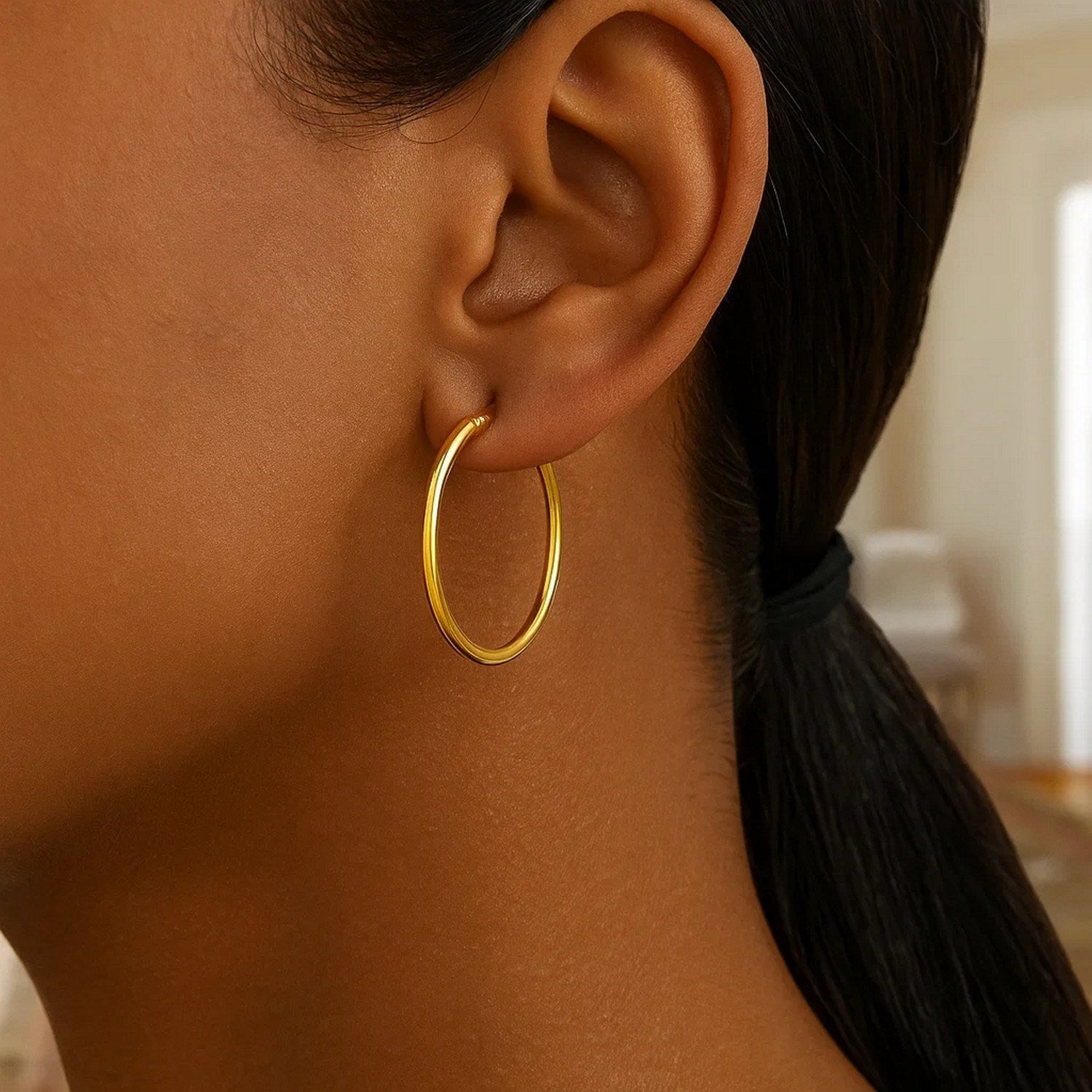 Polished 10k yellow gold hoop earrings, showcasing a modern design with a luxurious shine and elegant silhouette.
