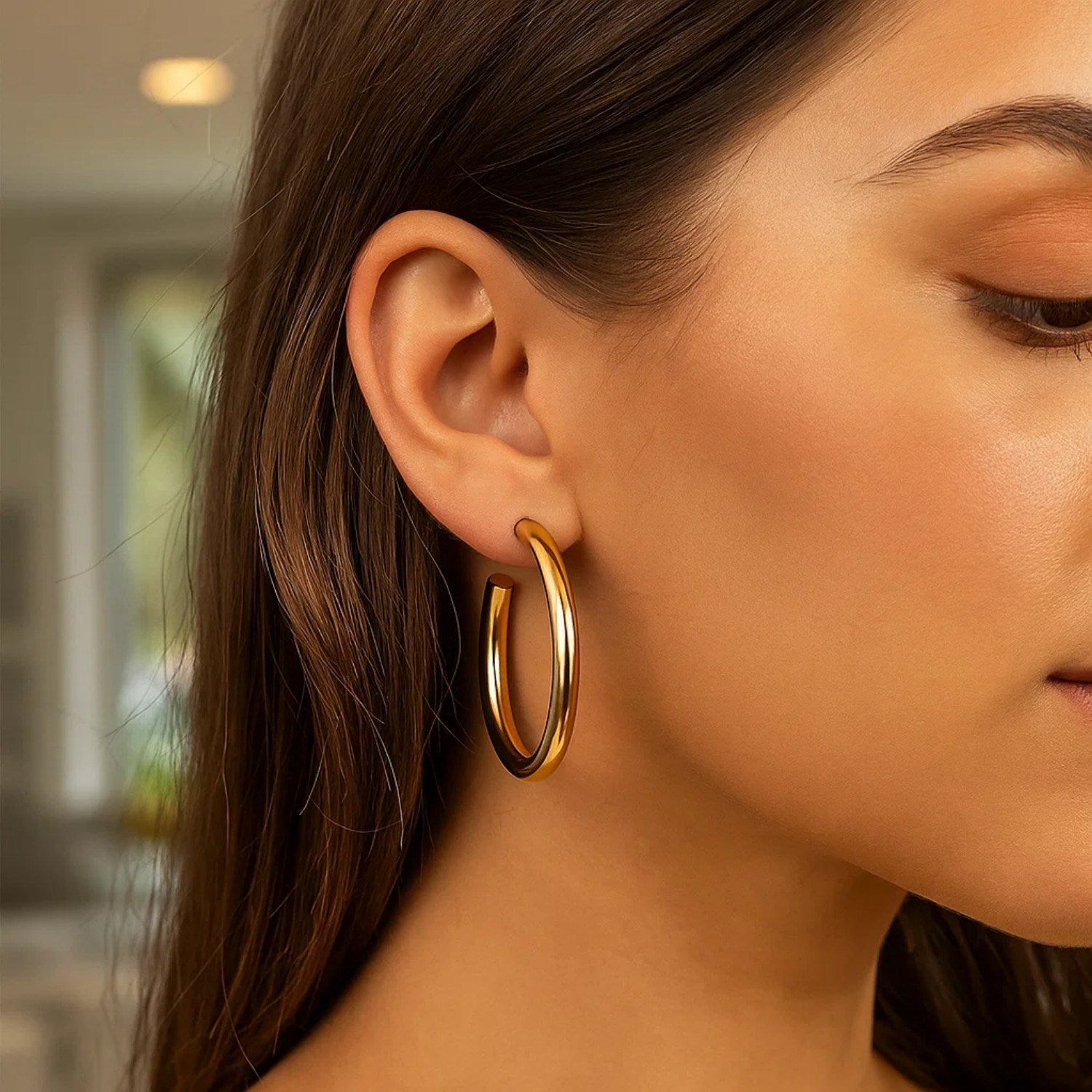 14k yellow gold polished hoop earrings showcasing a modern design with a sleek, luminous finish.