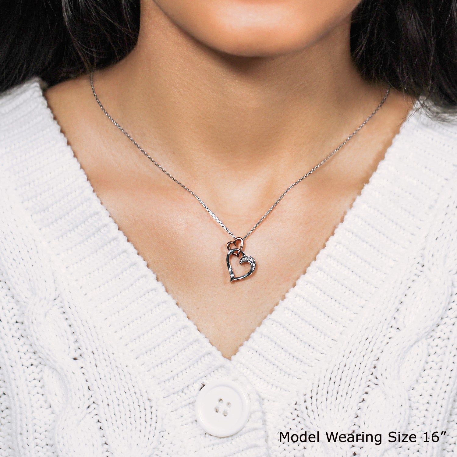 Sterling silver cascading dual heart pendant adorned with diamond accents, featuring a modern design and elegant chain.