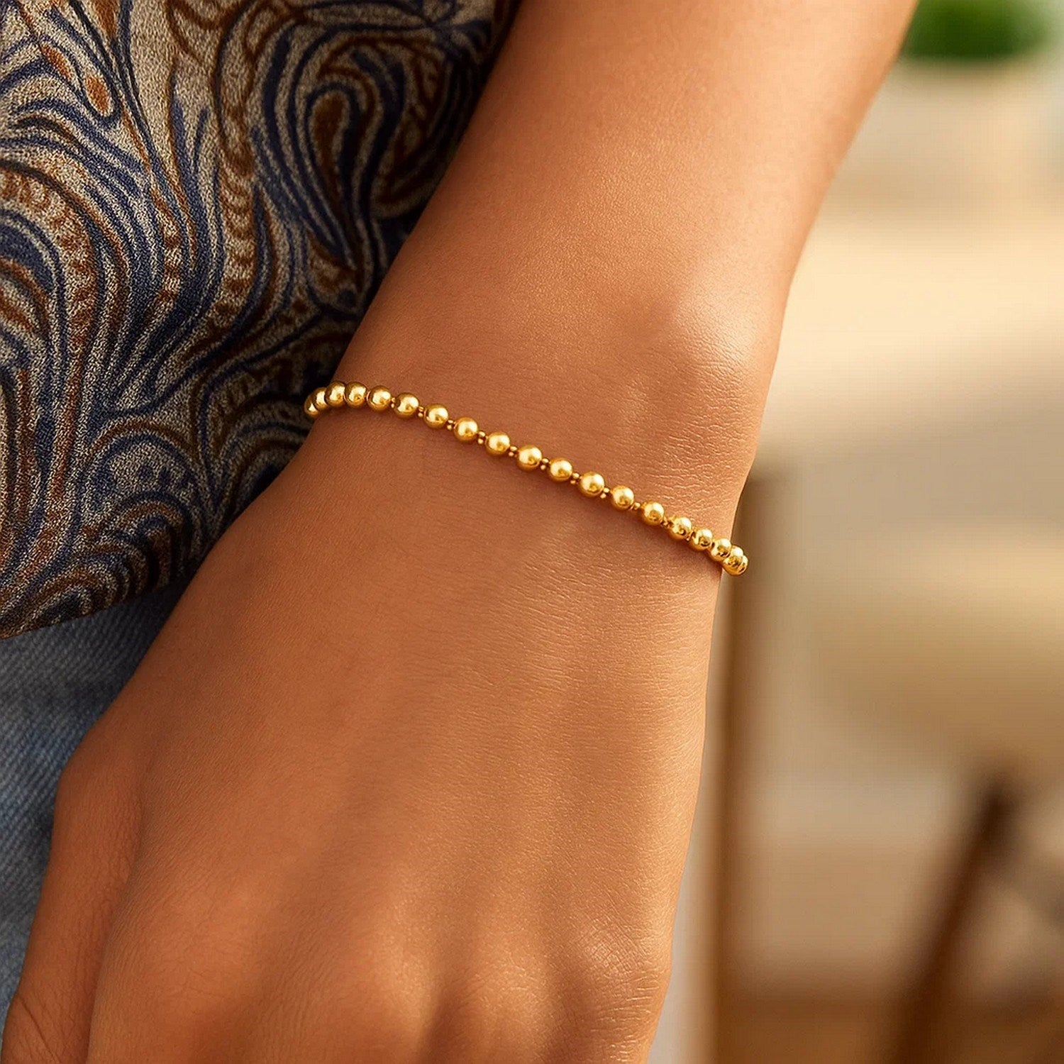 Duo bead bracelet in 14k yellow gold, modern design with elegant stud accents, showcasing refined luxury craftsmanship.