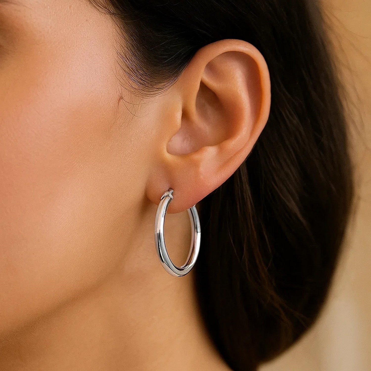 Sterling silver polished hoop earrings with rhodium plating, showcasing a modern design and elegant shine.