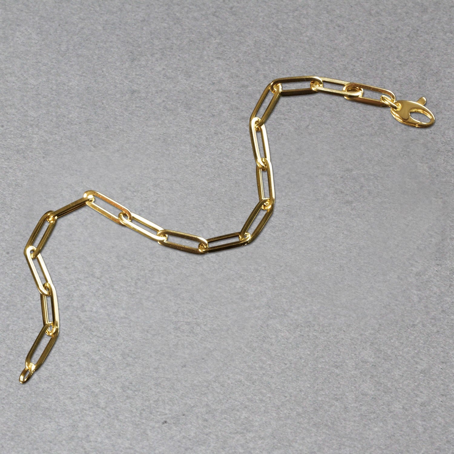14k yellow gold bold paperclip chain bracelet featuring a modern design with elegant round links.