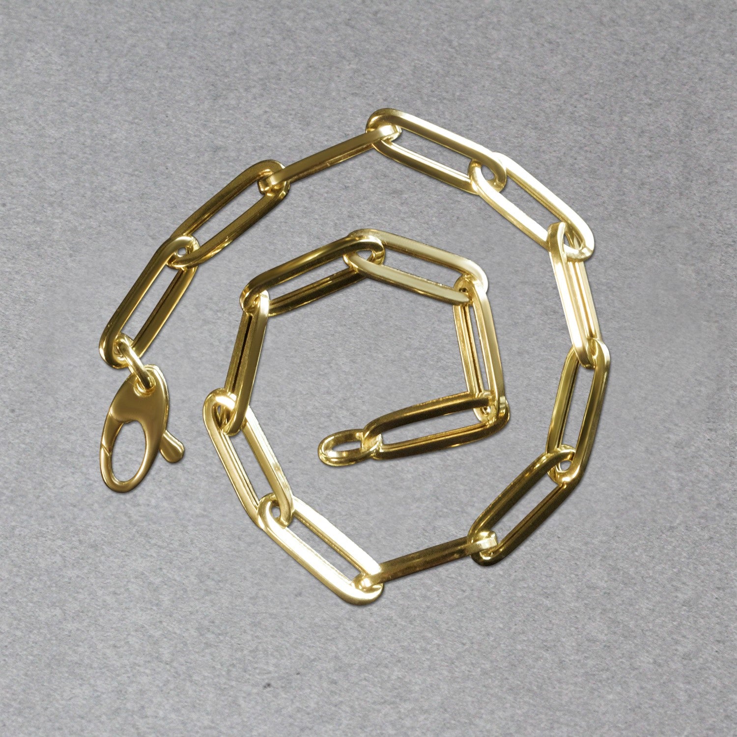 14K yellow gold bold paperclip chain bracelet, modern design with sleek round links, perfect for elegant layering.