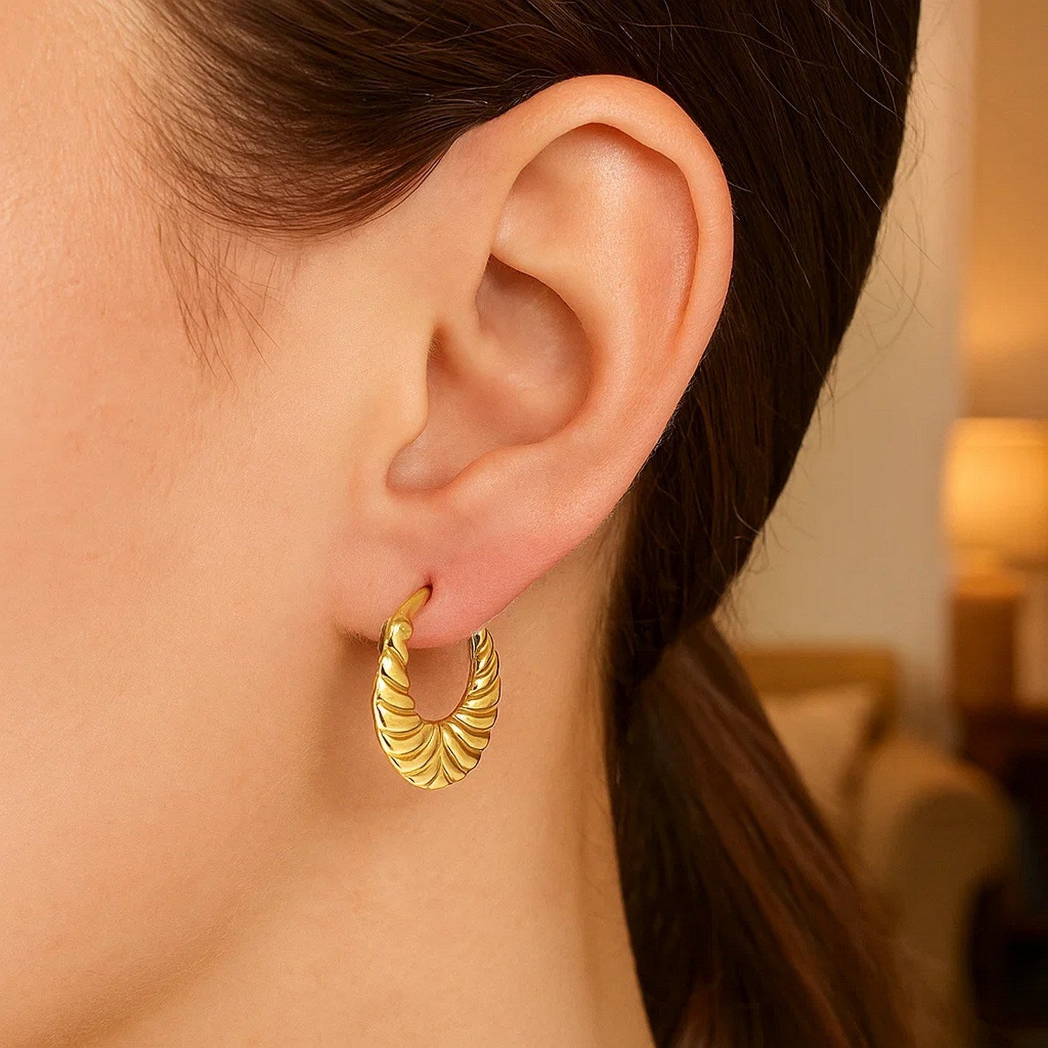 14K yellow gold graduated grooved hoop earrings showcasing a modern design with elegant curvature and refined finish.