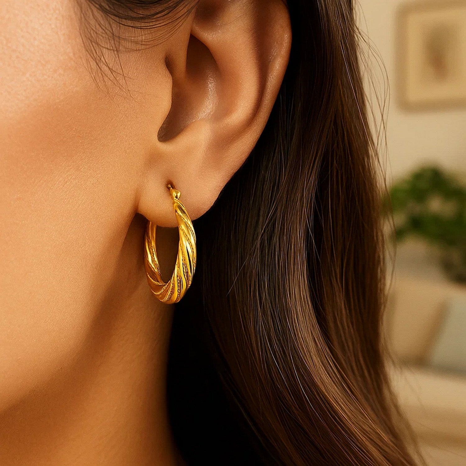 Textured 10k yellow gold graduated twist hoop earrings, showcasing modern elegance and luxurious craftsmanship.
