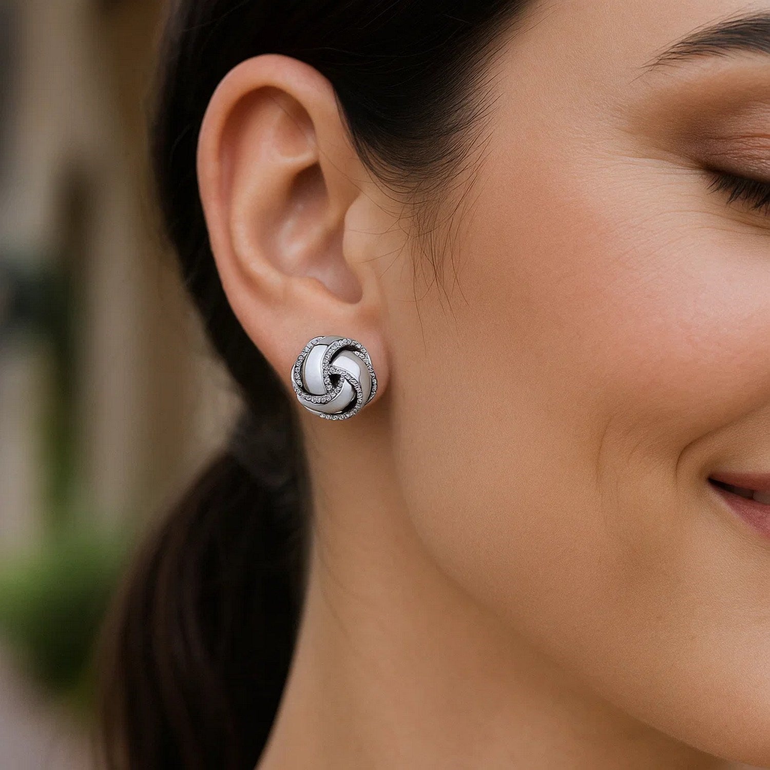 Sterling silver textured and polished love knot earrings showcasing modern luxury and exquisite craftsmanship.