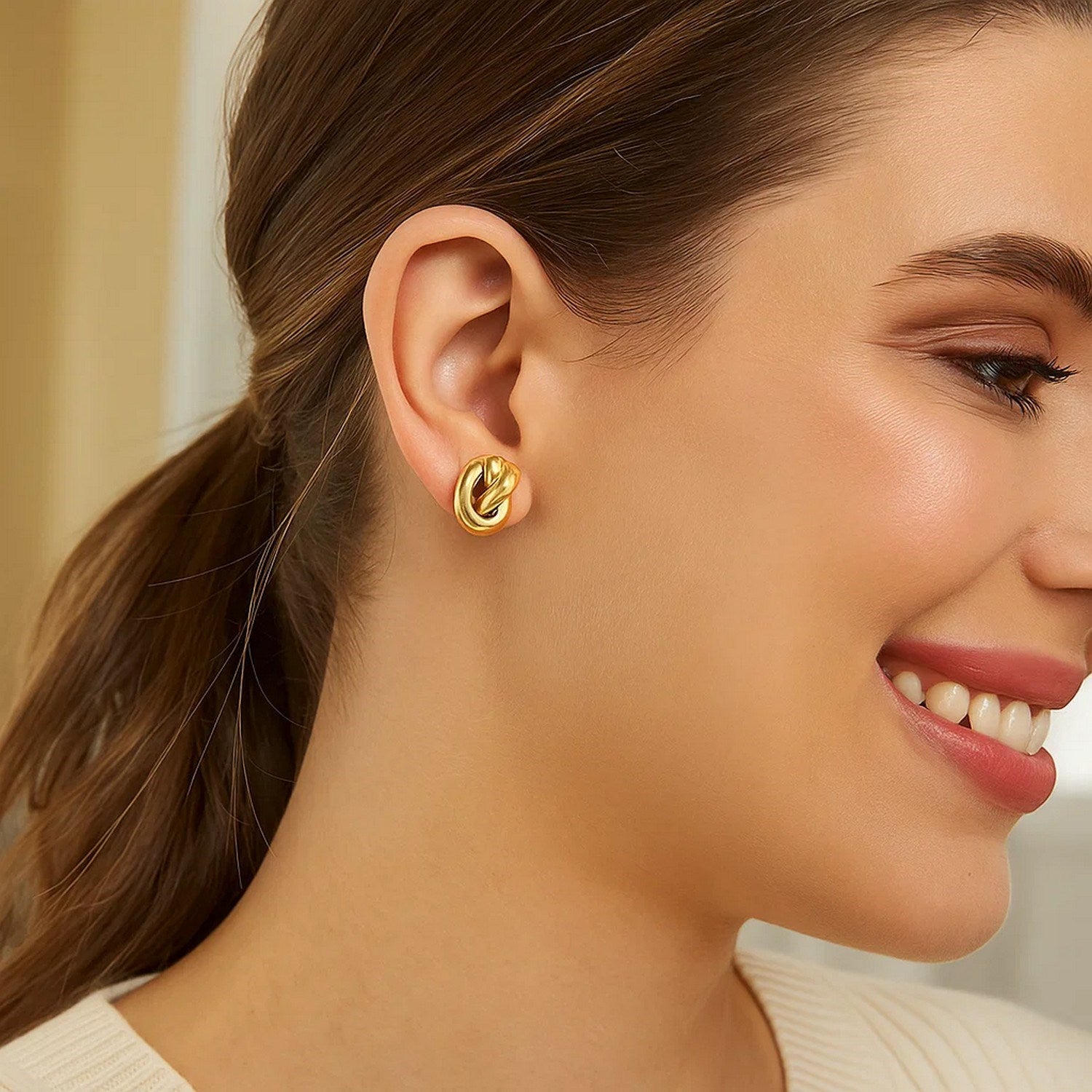 14k yellow gold polished knot stud earrings showcasing a modern design with a sleek, sophisticated finish.