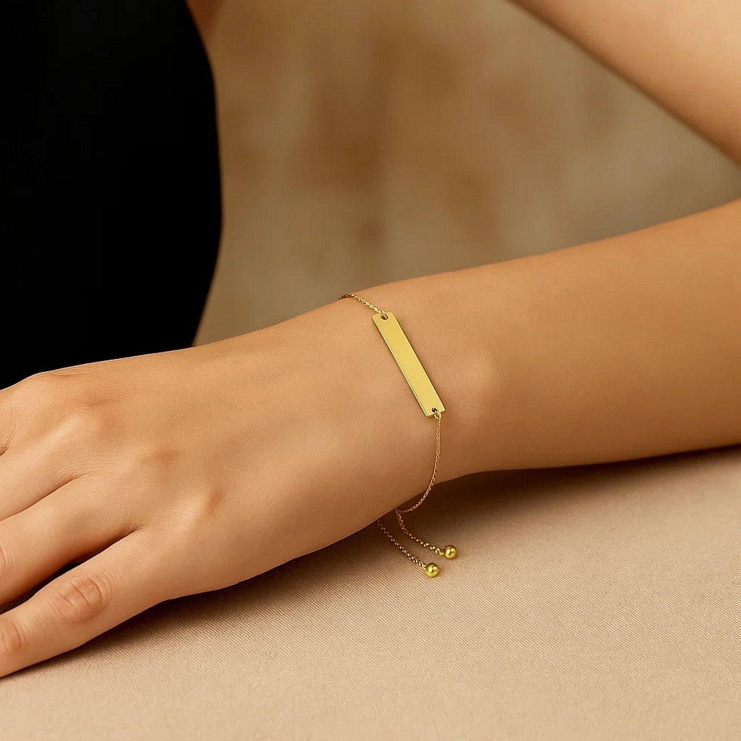 Adjustable 14k yellow gold bracelet featuring a sleek shiny bar, embodying modern luxury elegance.