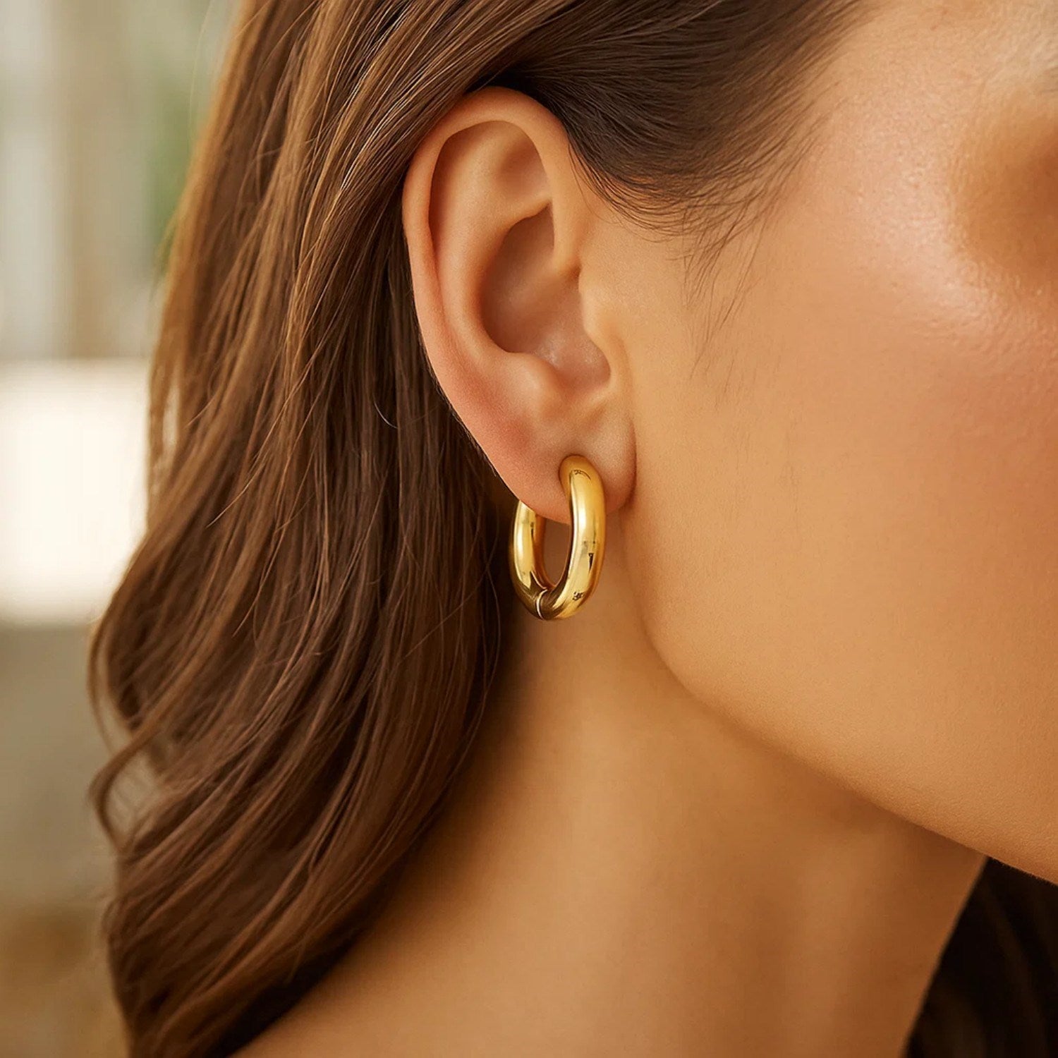 14K yellow gold polished hoop earrings with a modern design, showcasing a sleek and elegant round silhouette.