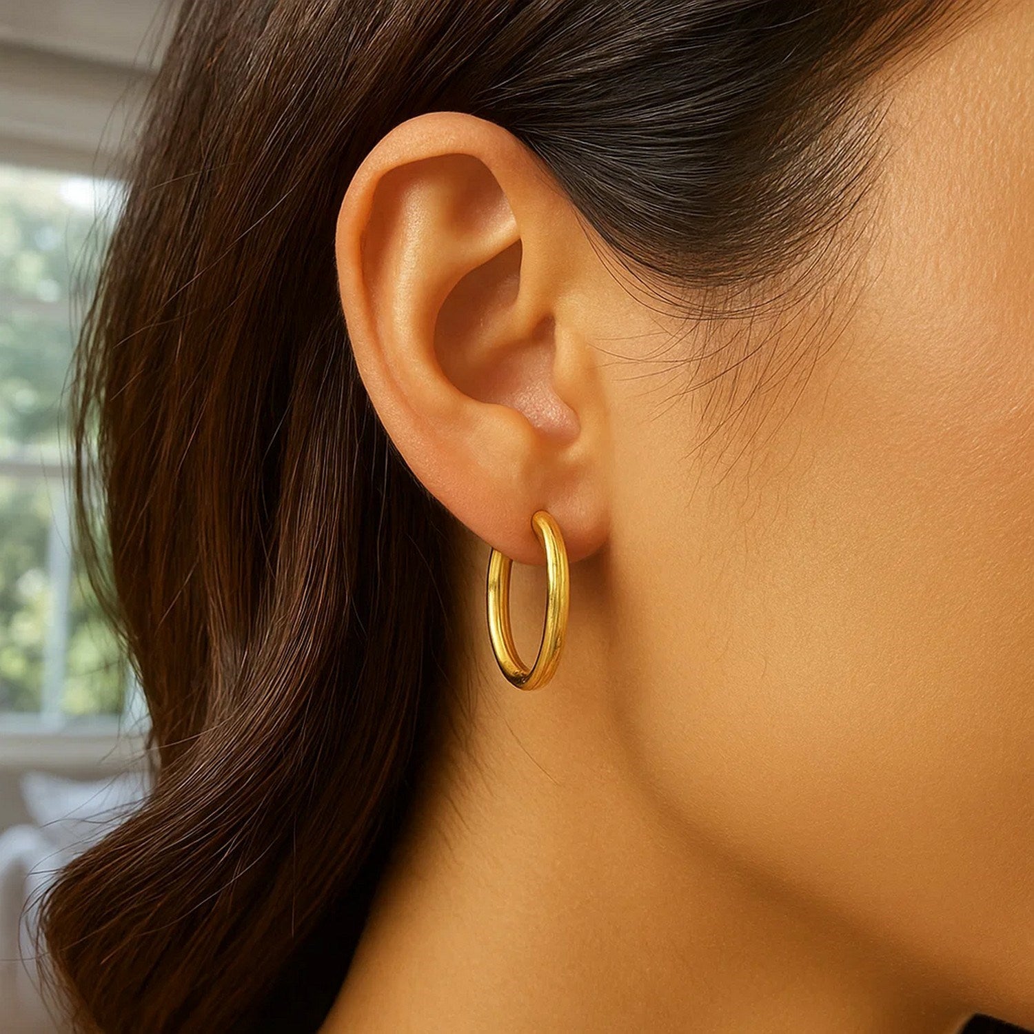 14k yellow gold textured hoop earrings with a modern oval design, perfect for elegant occasions.