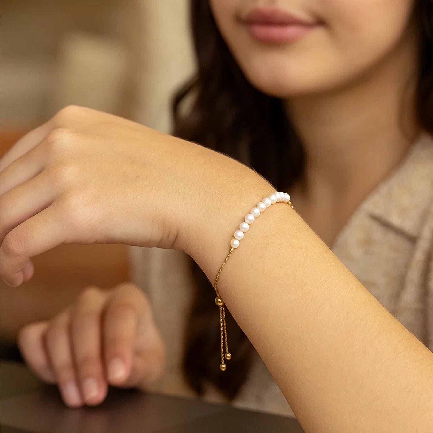 14k yellow gold adjustable friendship bracelet adorned with lustrous pearls in a modern round design.