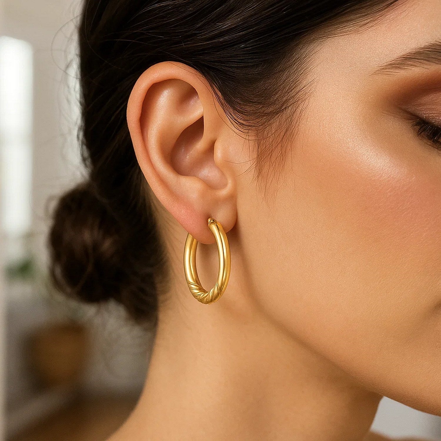 14K yellow gold twisted medium hoop earrings showcasing a modern design with elegant craftsmanship and a luxurious finish.