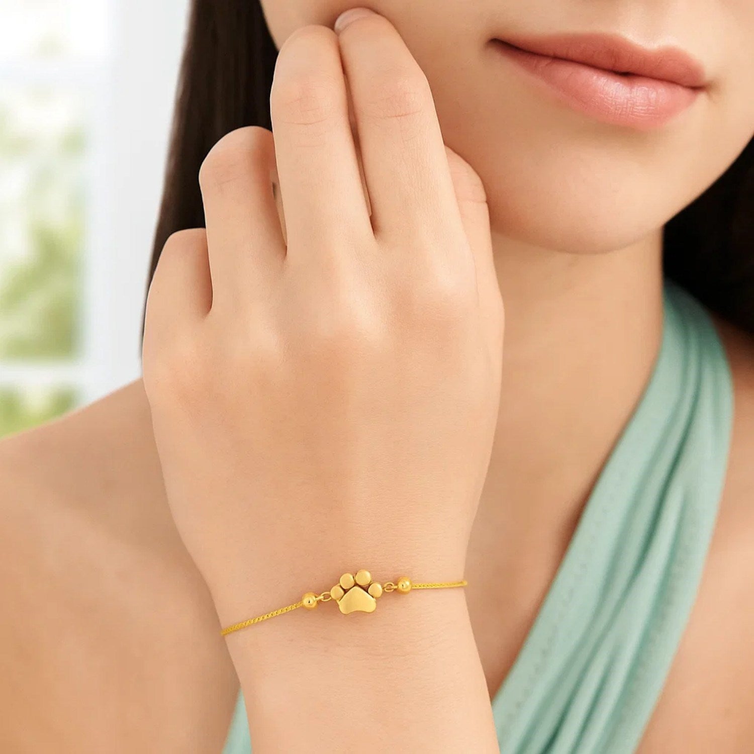 Elegant 14k yellow gold adjustable bracelet featuring a charming paw print design and delicate chain detail.