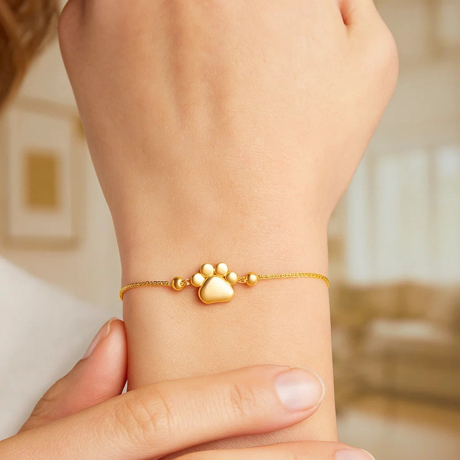 14k yellow gold adjustable bracelet featuring an elegant paw print design on a delicate chain.