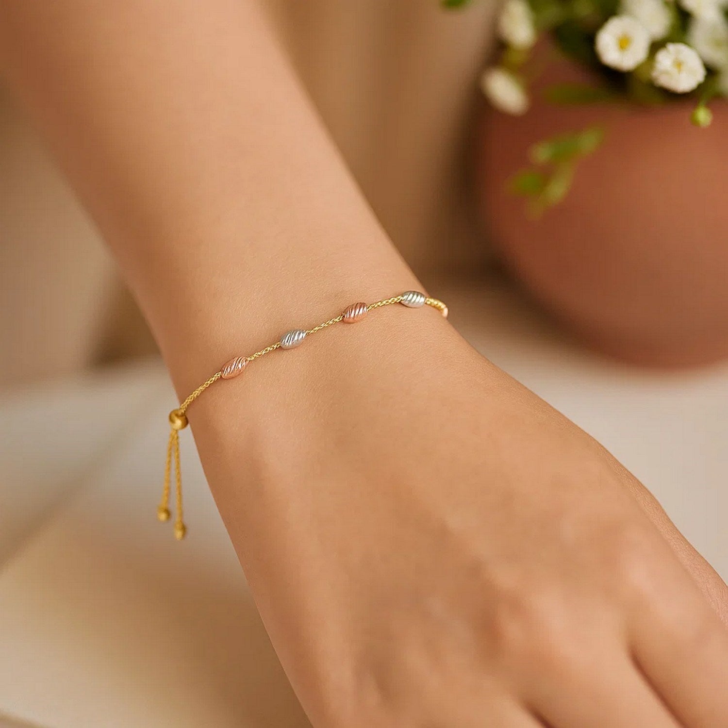 14k tri-color gold textured oval station lariat bracelet featuring elegant links and sparkling diamond accents.