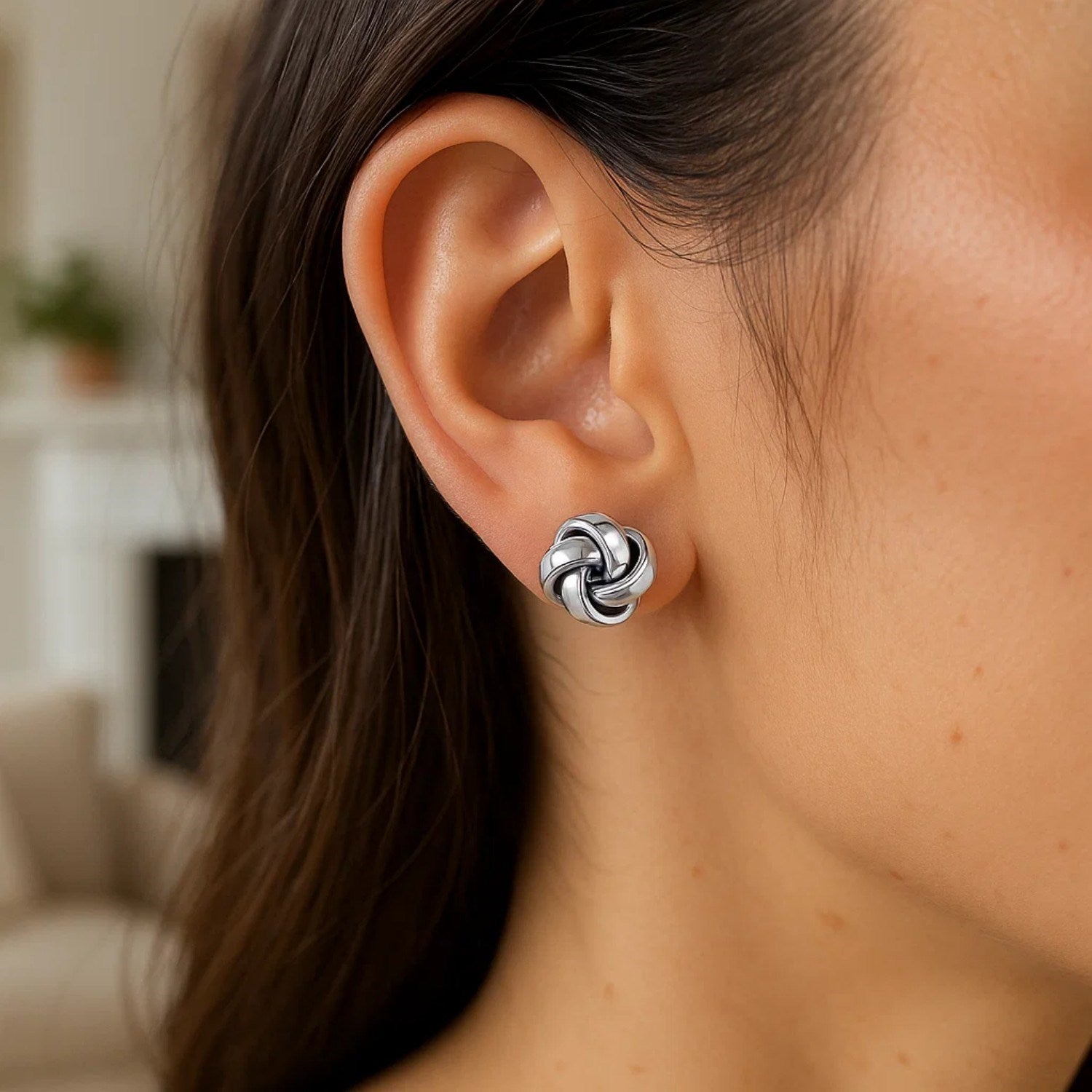 Sterling silver polished love knot earrings with a modern design, embodying elegance and luxury for any occasion.