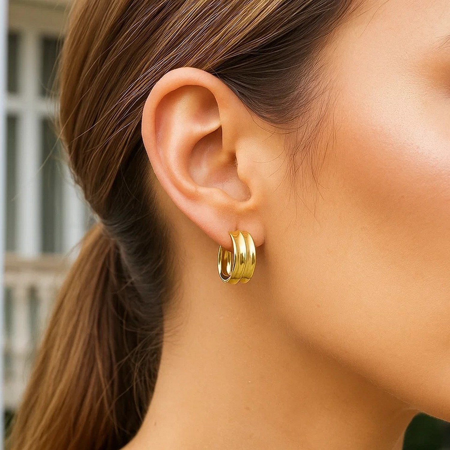 14k yellow gold medium concave hoop earrings showcasing a modern design with a sleek, polished finish.