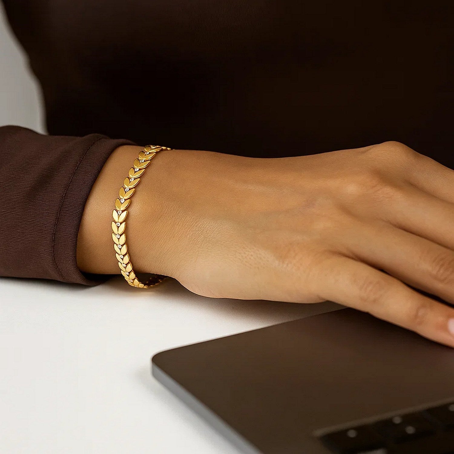 Elegant 14k yellow gold bracelet featuring a laurel leaf design adorned with sparkling diamonds.