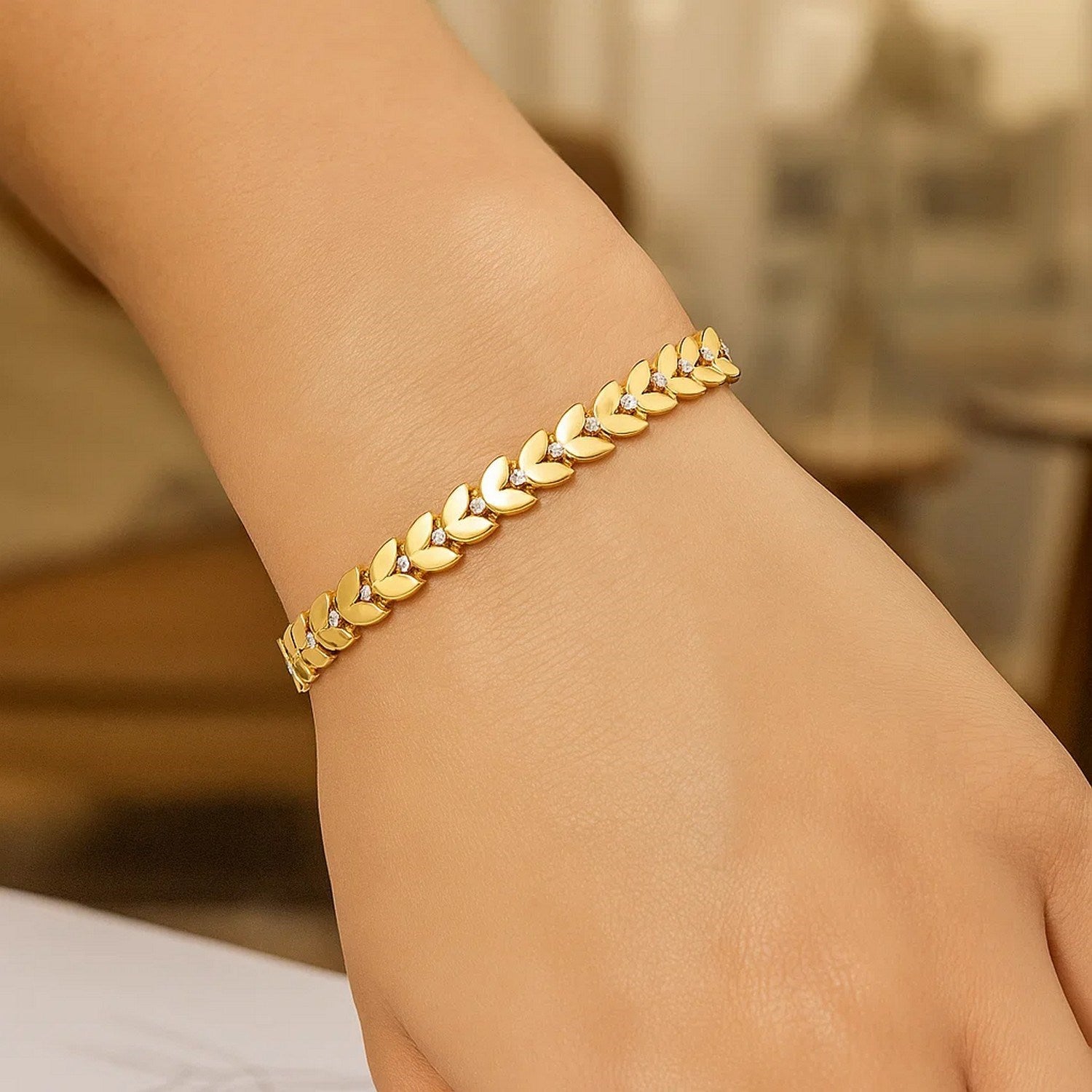 Elegant 14k yellow gold bracelet featuring laurel leaf design and sparkling diamond accents, perfect for luxury occasions.