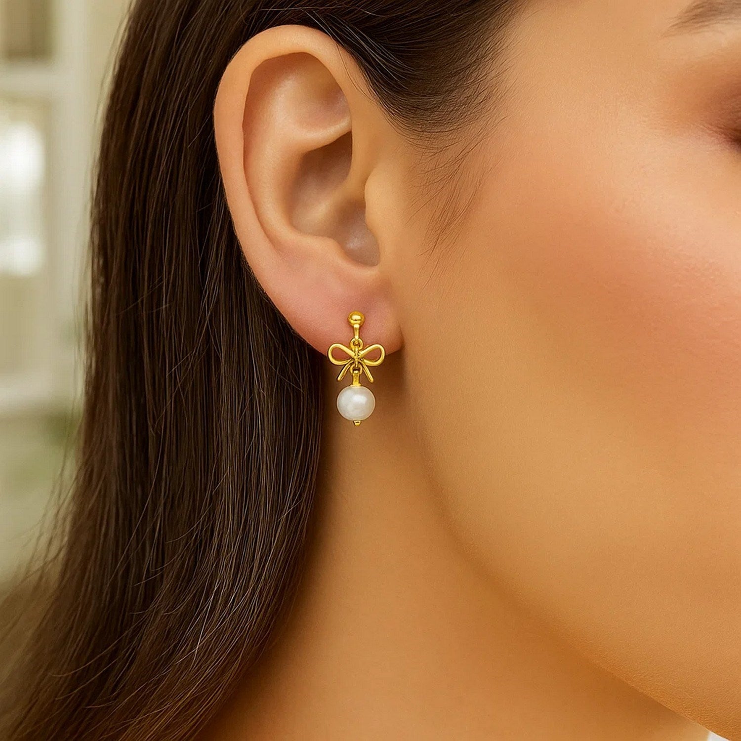 14K yellow gold drop earrings featuring elegant freshwater pearls in a classic bow design.