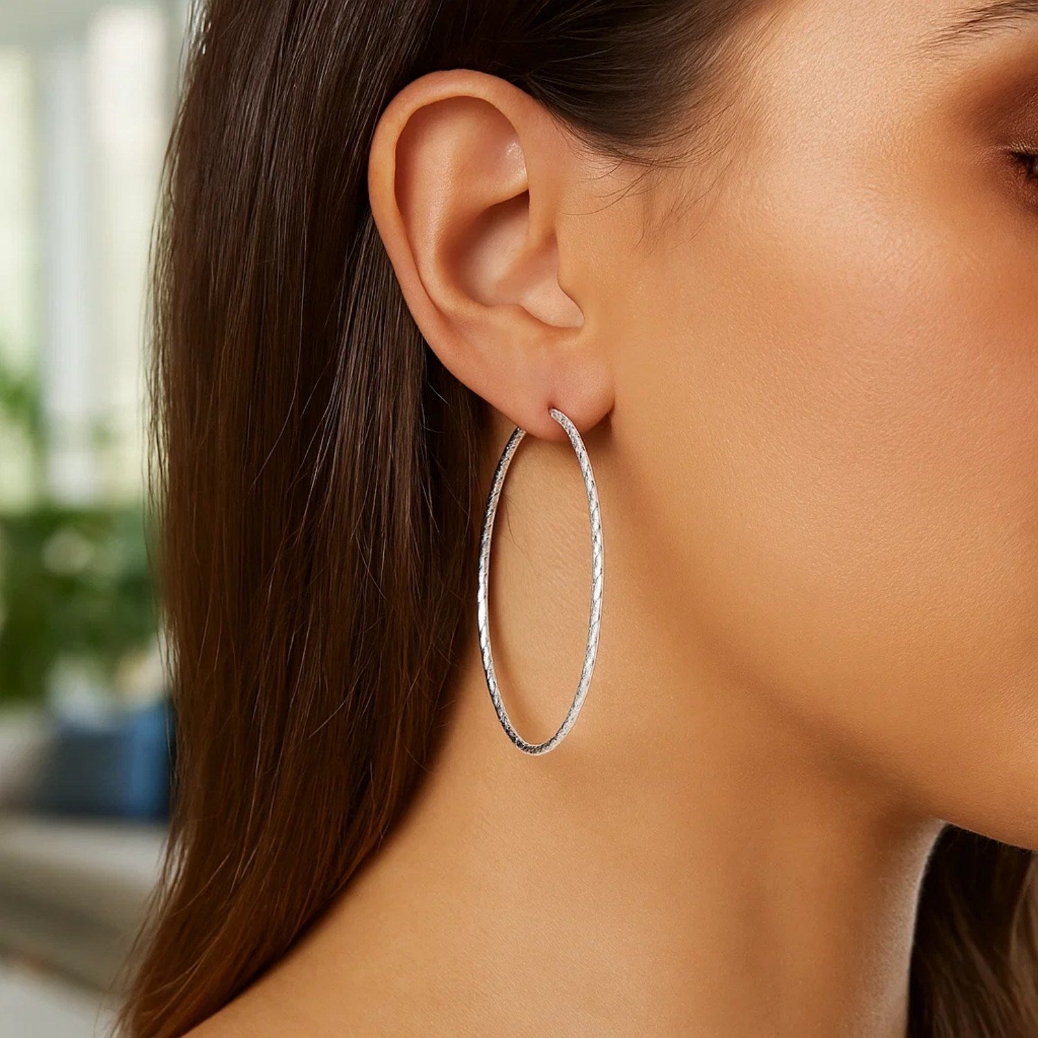 Sterling silver textured large round hoop earrings, modern design with elegant shine and secure closure.