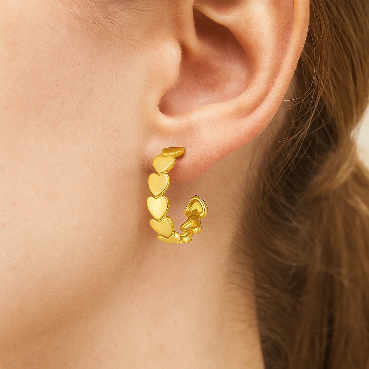 Elegant 14k yellow gold hoop earrings featuring a heart row design, perfect for sophisticated occasions.
