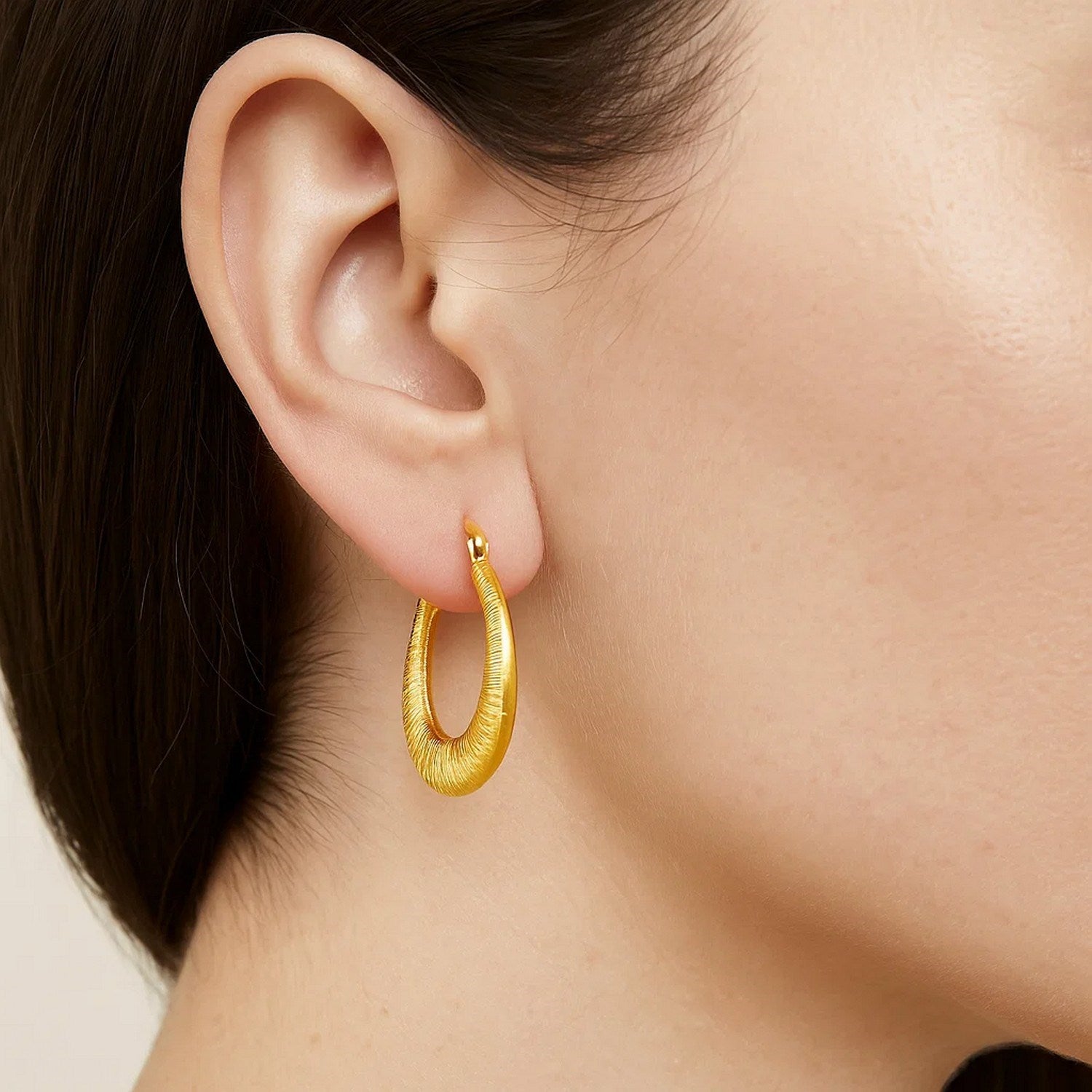 Elegant 14k yellow gold textured hoop earrings showcasing a refined round design, perfect for luxurious occasions.