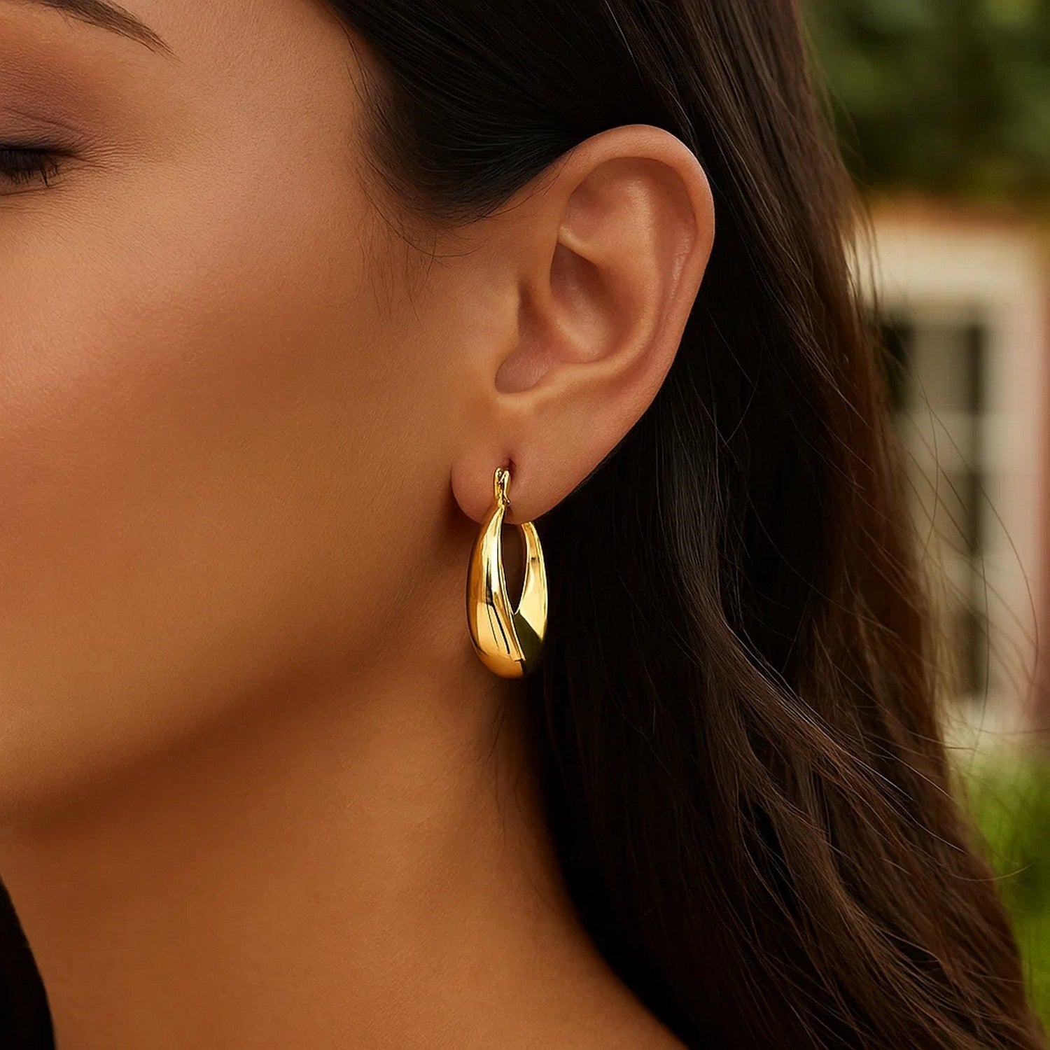 14k yellow gold polished puffed hoop earrings showcasing a modern design with a luxurious shine and elegant silhouette.