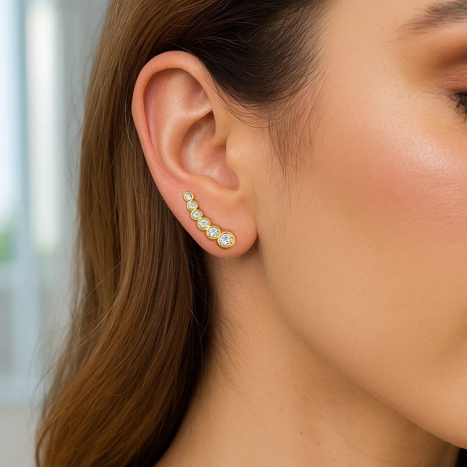 14k yellow gold graduated circles climber earrings adorned with sparkling cubic zirconias in a modern design.