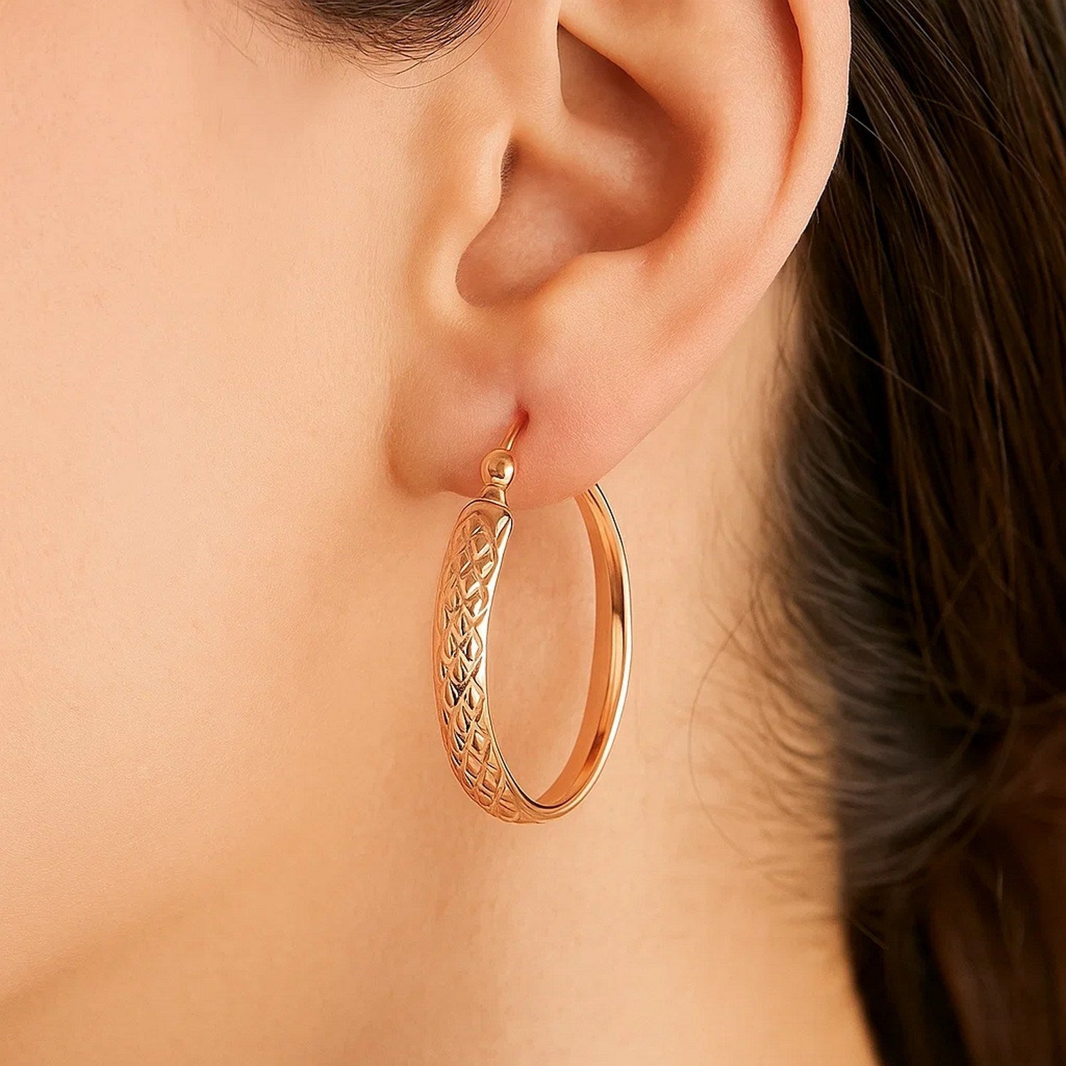 14k rose gold hammered oval hoop earrings showcasing a contemporary design for elegant sophistication.