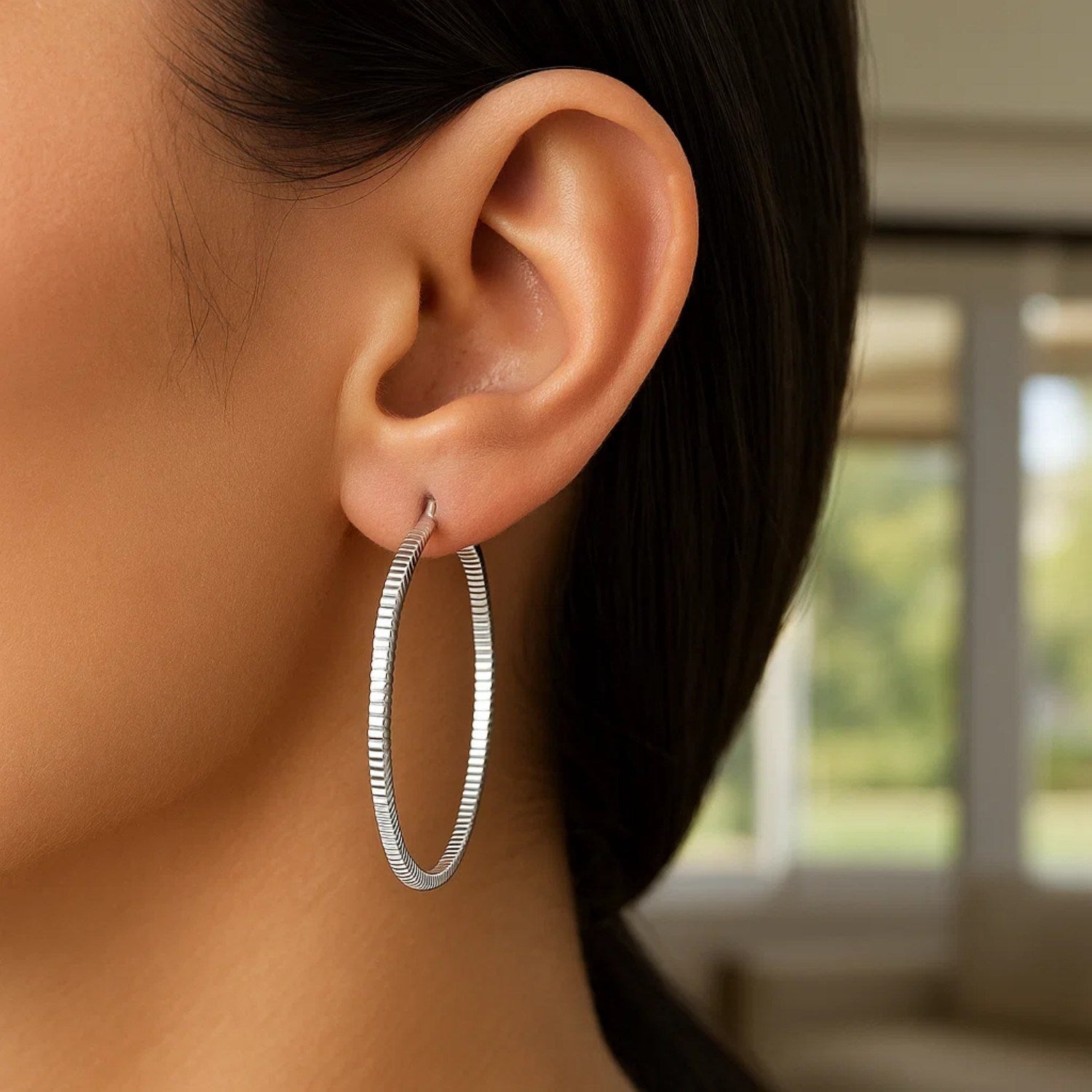 Sterling silver textured hoop earrings showcasing modern design and elegant craftsmanship for a luxurious look.