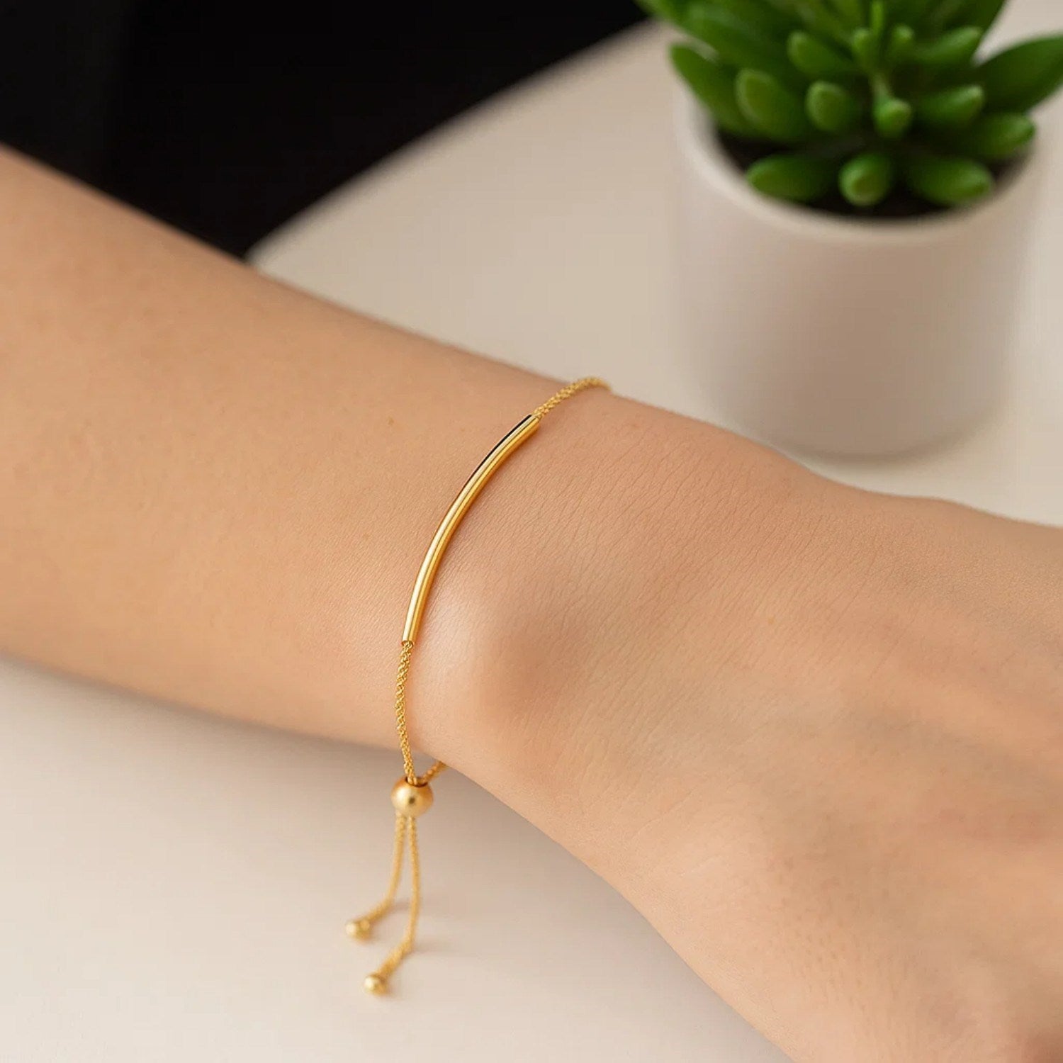 14k yellow gold smooth curved bar lariat bracelet featuring a delicate chain for a modern, elegant look.